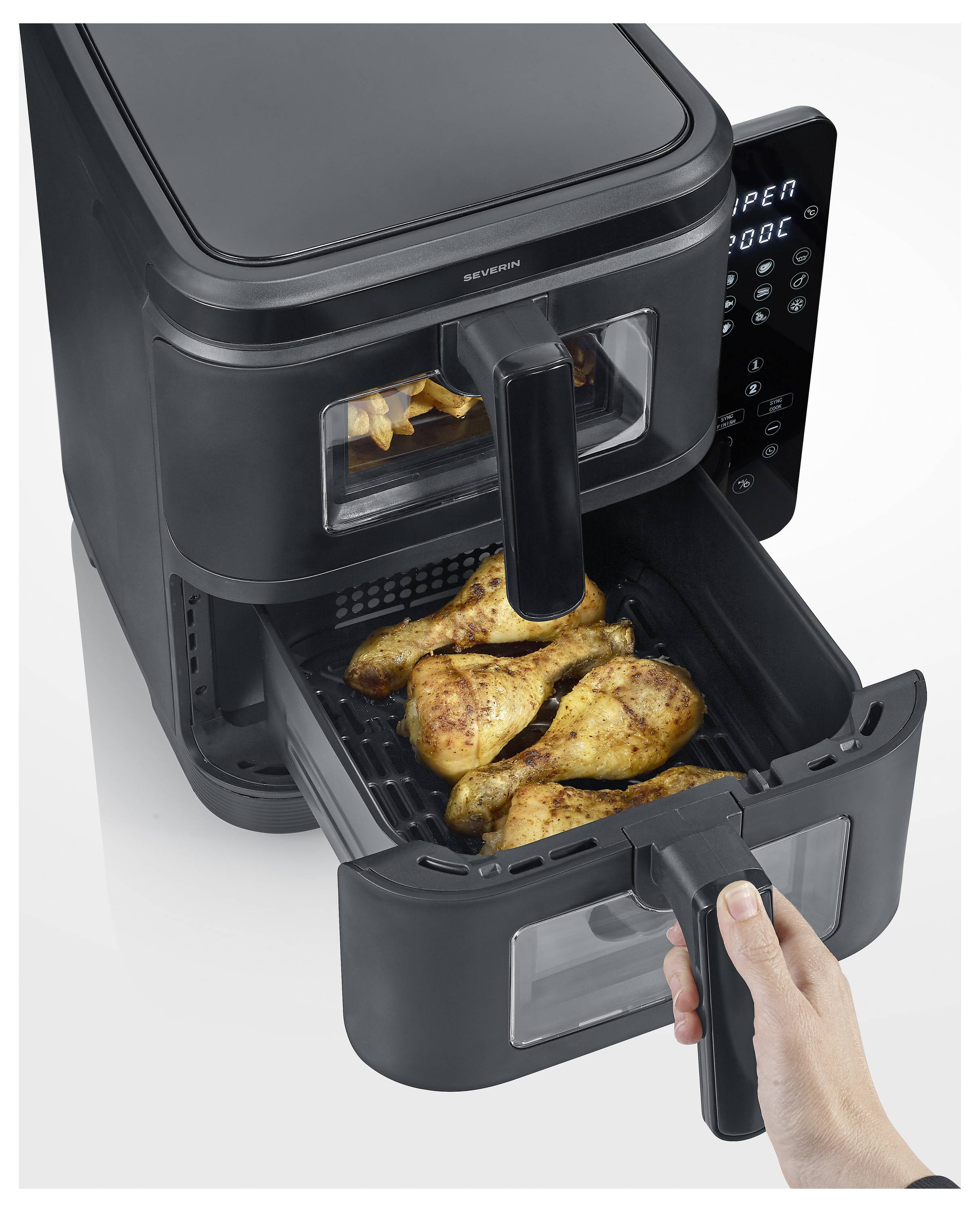 Ein Heißluftfritteusegerät mit digitaler Anzeige wird gezeigt, mit Tabletts, die gekochtes Hähnchen enthalten. Eine Hand zieht eines der Tabletts heraus.