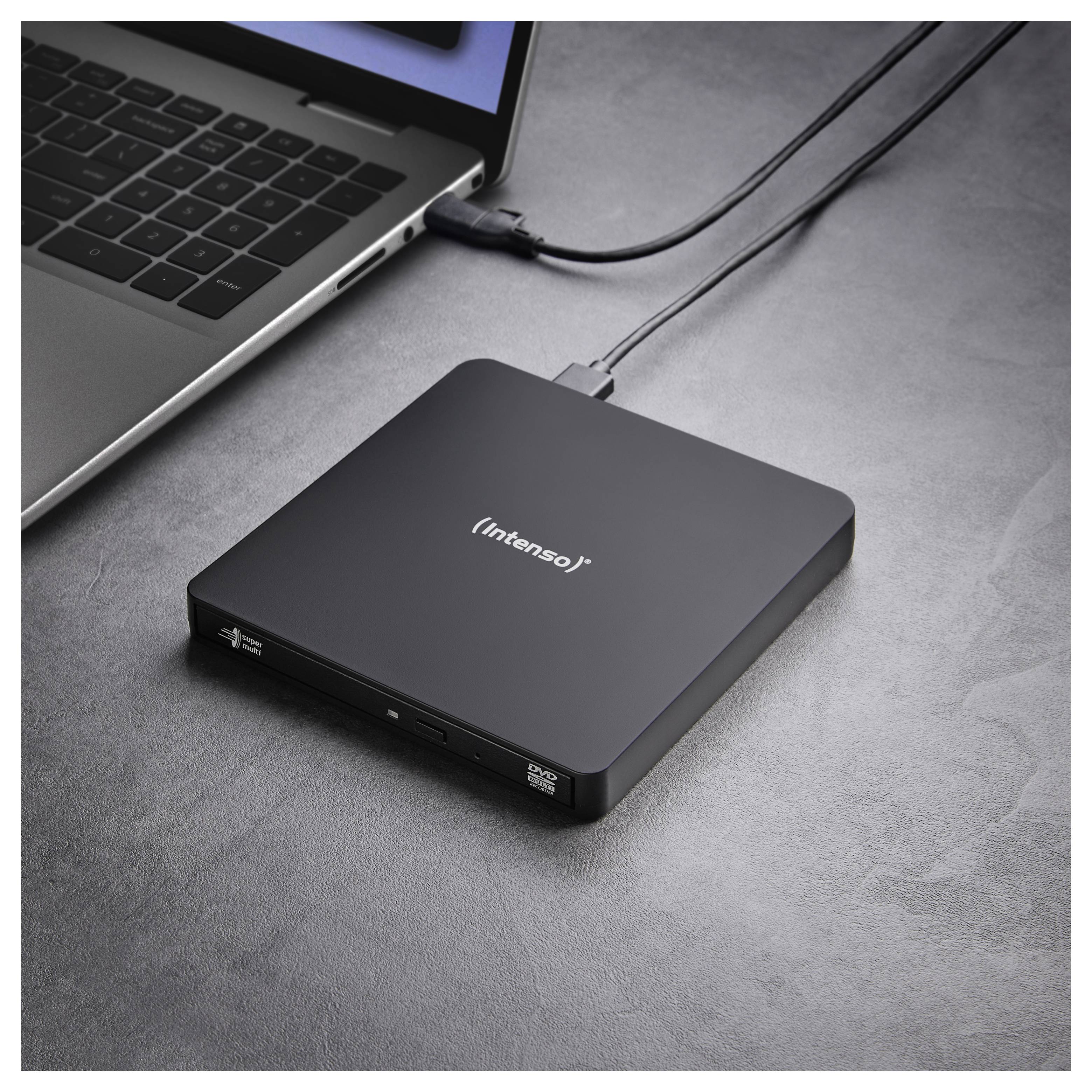 Externes DVD-Laufwerk, das an einem Laptop auf einer grauen Oberfläche angeschlossen ist, wobei sein schlankes Design und die USB-Verbindung hervorgehoben werden.