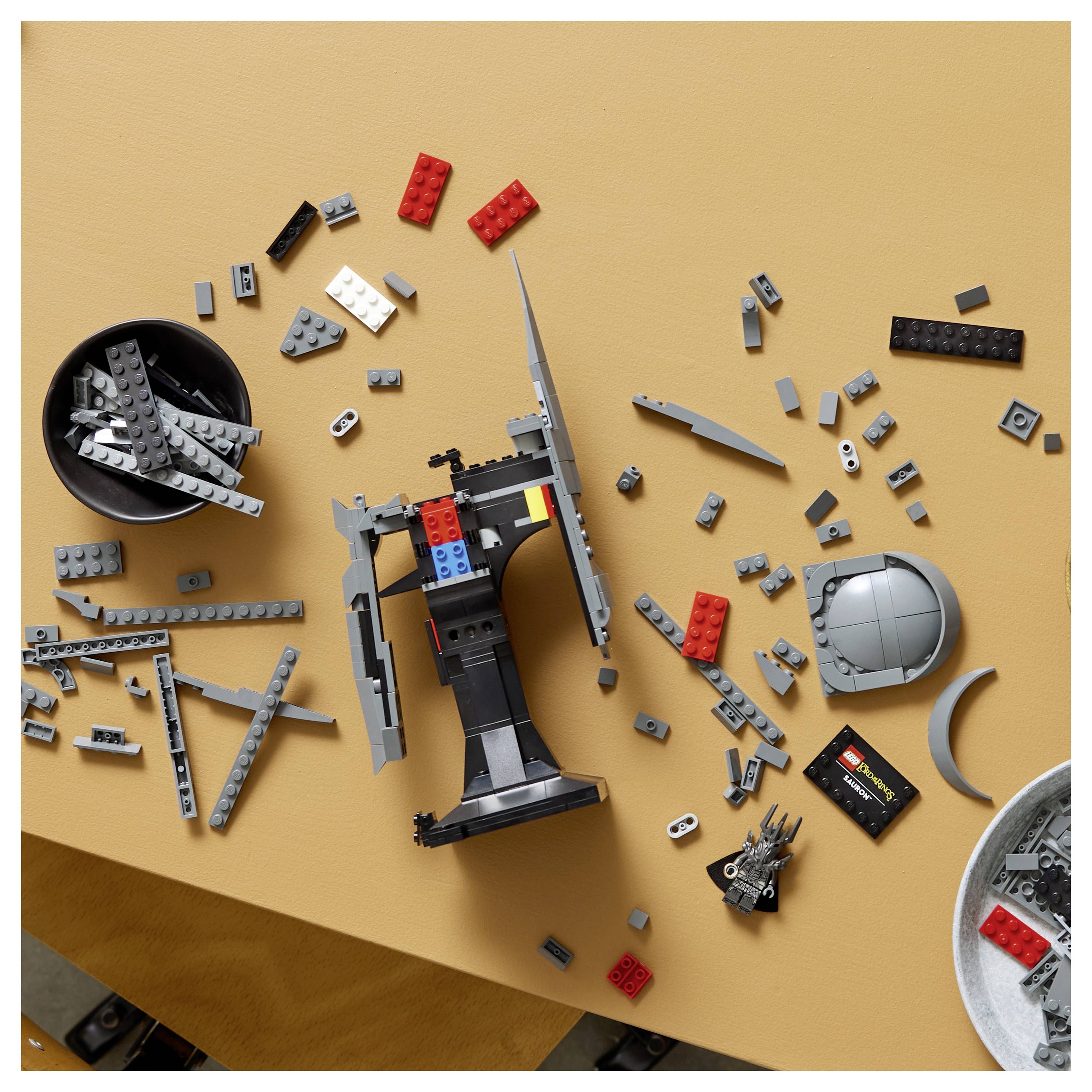 Verstreute Legosteine auf einem Tisch, teilweise zu einem Modell zusammengebaut, das einem Raumschiff oder einer Raumstation ähnelt.