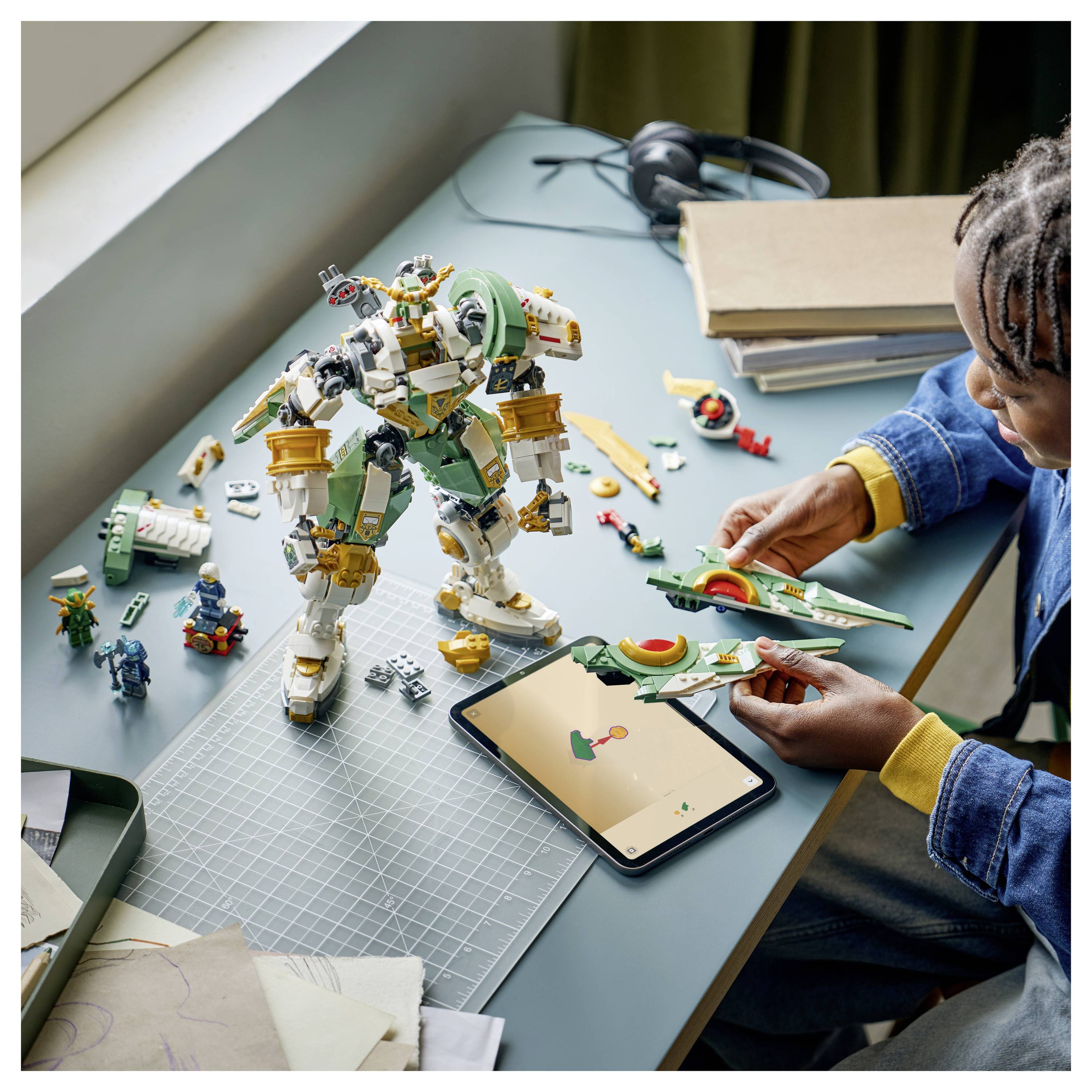 Eine Person montiert ein grün-weißes Robotermodell an einem Schreibtisch mit Werkzeugen und Teilen in der Nähe und zeigt dabei Kreativität und Konzentration.