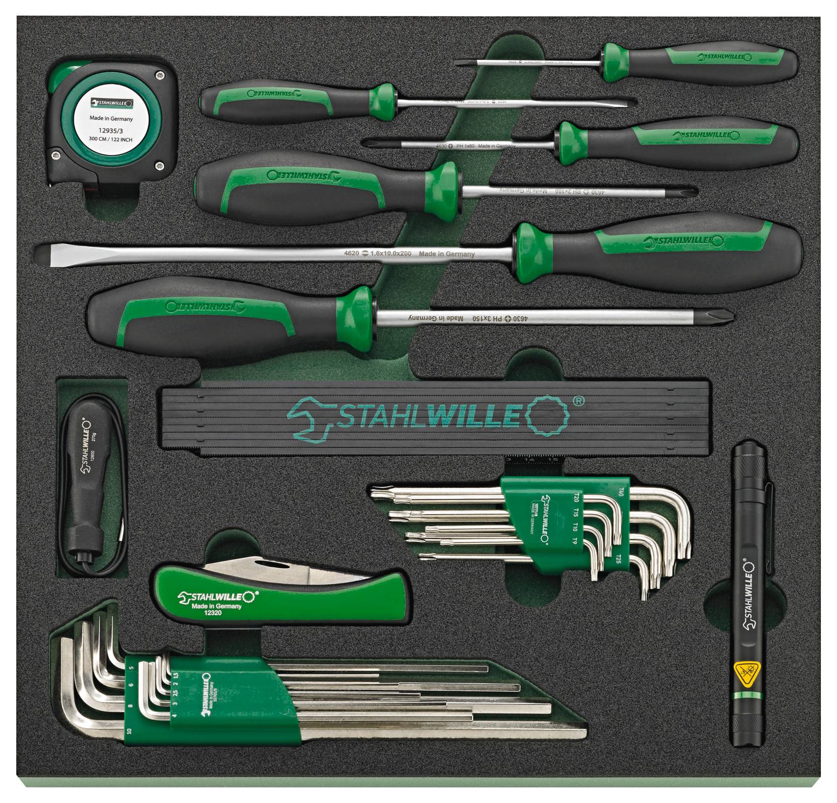 Ein Werkzeugsatz in einem schwarzen Schaumstoffkoffer mit grünen Griffen Schraubendrehern, einem Stahllineal, Innensechskantschlüsseln und einer Stirnlampe, beschriftet mit „STAHLWILLE
