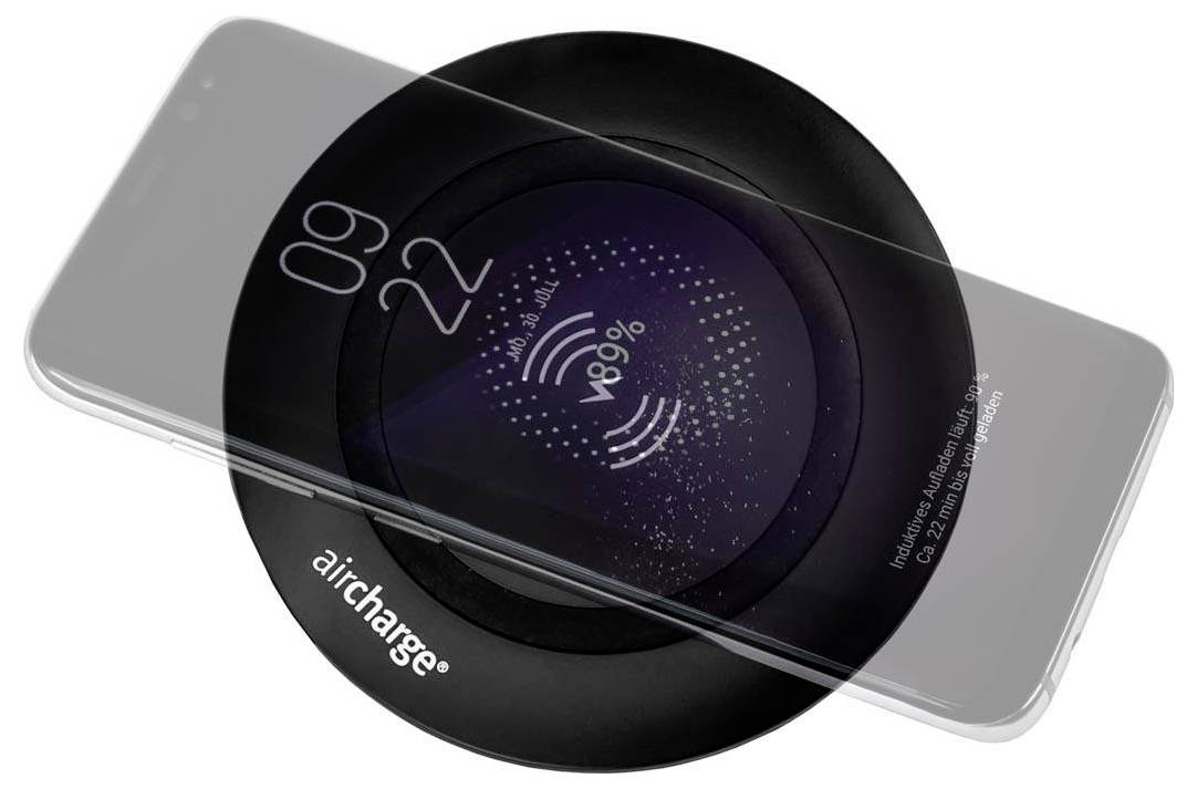 Ein Smartphone lädt drahtlos auf einem runden schwarzen Ladegerät mit der Aufschrift „aircharge