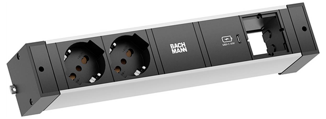Eine Steckerleiste mit zwei europäischen Steckdosen, einem USB-Anschluss und Platz für zusätzliche Verbindungen; mit der Bezeichnung 