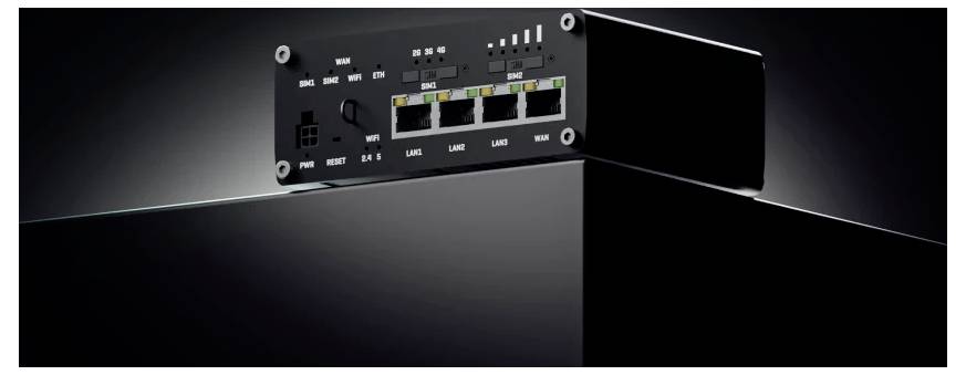 Schwarzes rechteckiges elektronisches Gerät mit sichtbarem Rückpaneel, das drei beschriftete Koaxialstecker zeigt: Mobile Main, GPS, Mobile Aux und einen USB-Anschluss.