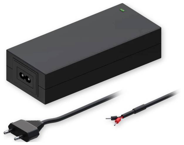 Ein schwarzes Netzteil mit einer grünen Kontrollleuchte, ausgestattet mit einem Eingangsstecker, der mit europäischen Steckdosen kompatibel ist, und einem Gleichstrom-Ausgangskabel.
