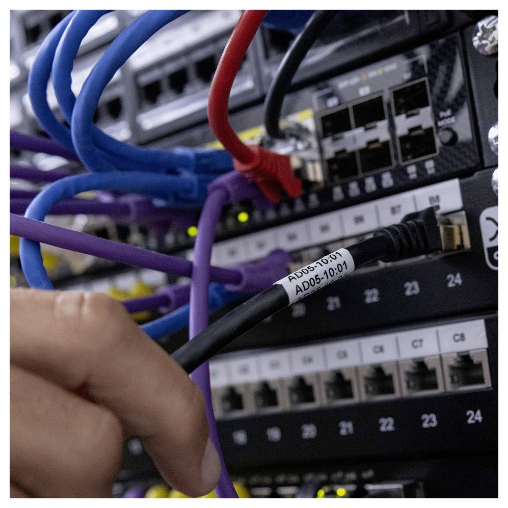 Eine Person verbindet ein schwarzes Netzwerkkabel mit der Bezeichnung „AD05-10-01