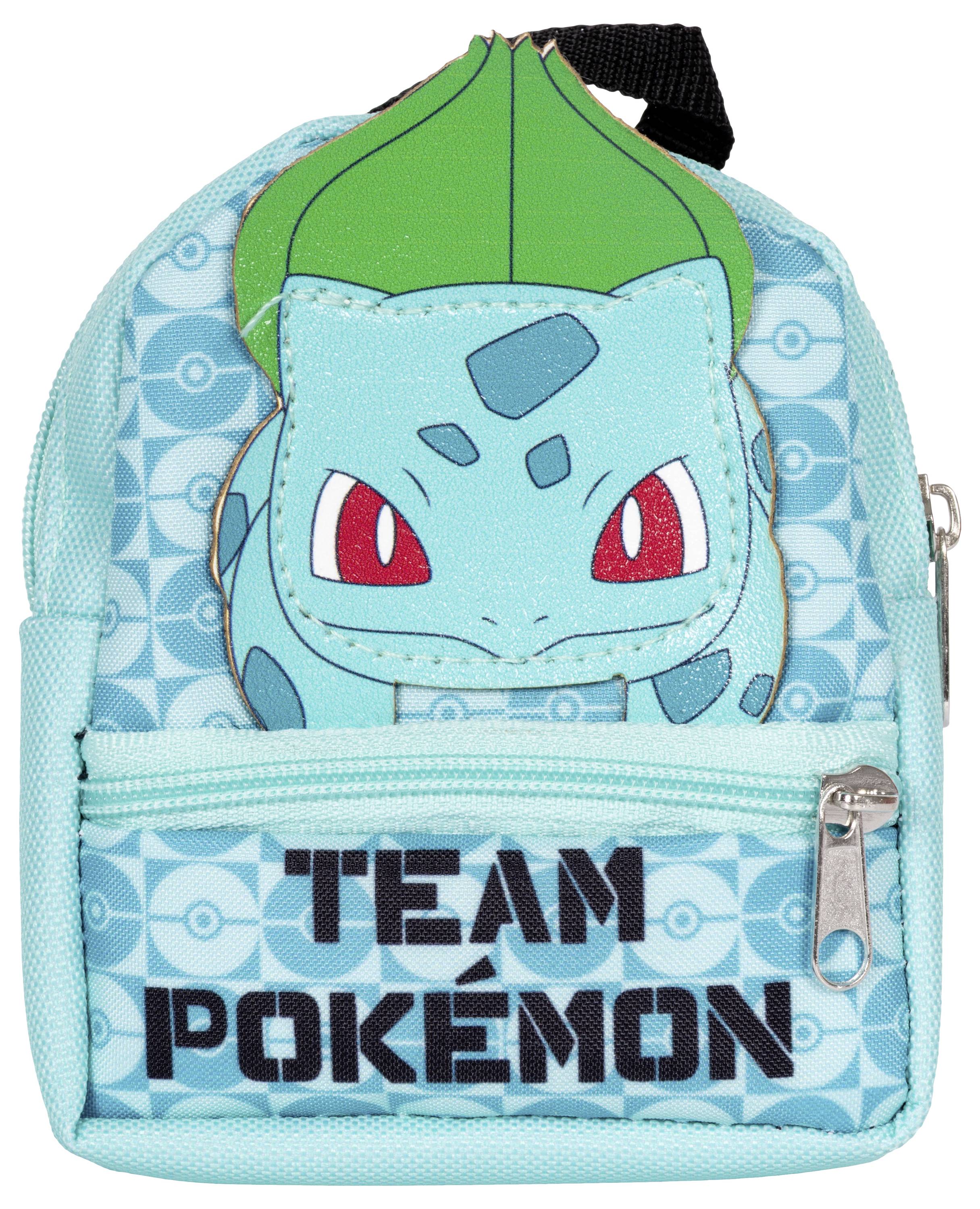 Ein kleiner blauer Rucksack mit einer Cartooncharakter-Figur, die ein grünes Blatt auf dem Kopf und rote Augen hat. Darunter steht der Text „Team Pokémon