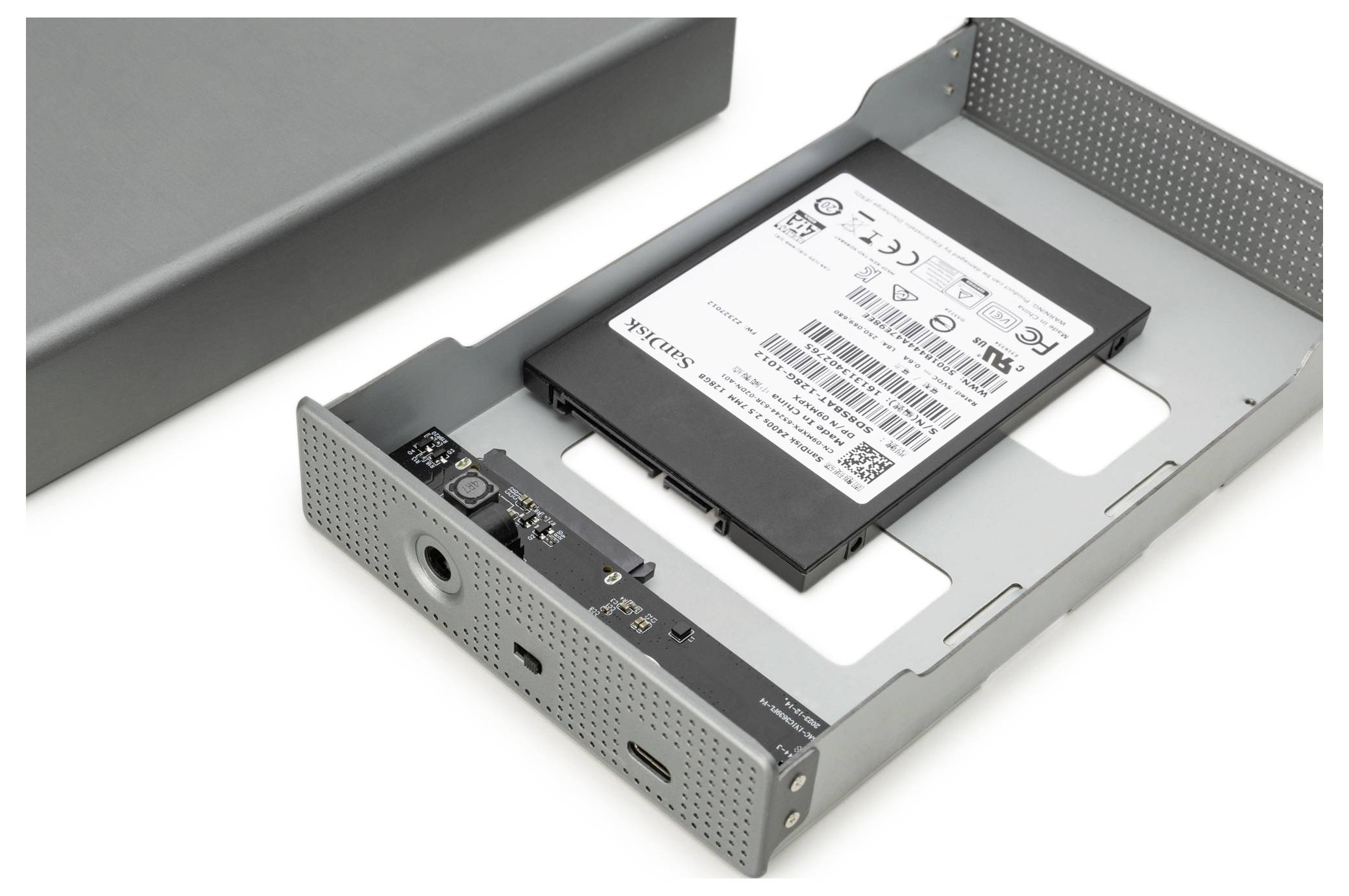 Ein elektronisches Gerät mit einer teilweise in ein Metallgehäuse eingesetzten Batterie. Die Batterie hat ein Etikett mit technischen Details und Symbolen.