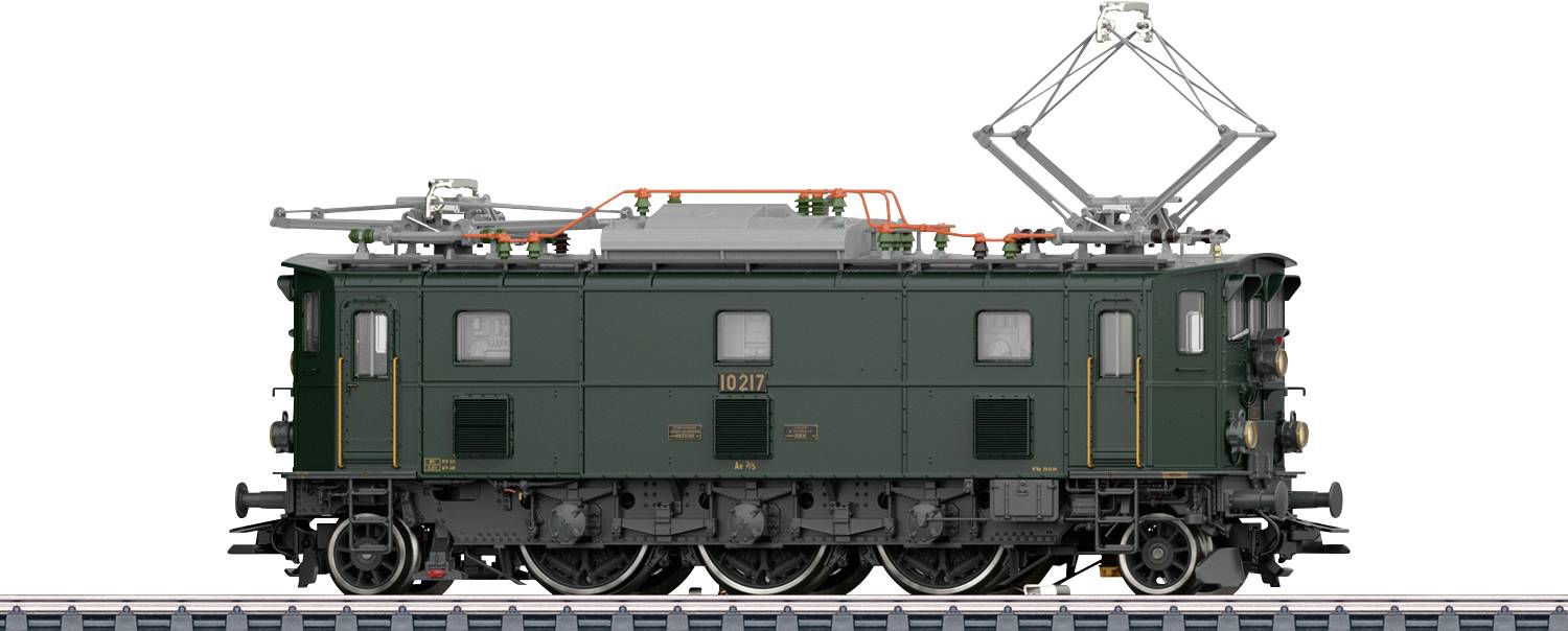 Eine alte grüne Zuglokomotive auf einem Eisenbahngleis mit Stromabnehmern über Kopf und aufwendigen Details am Lokomotivkörper.