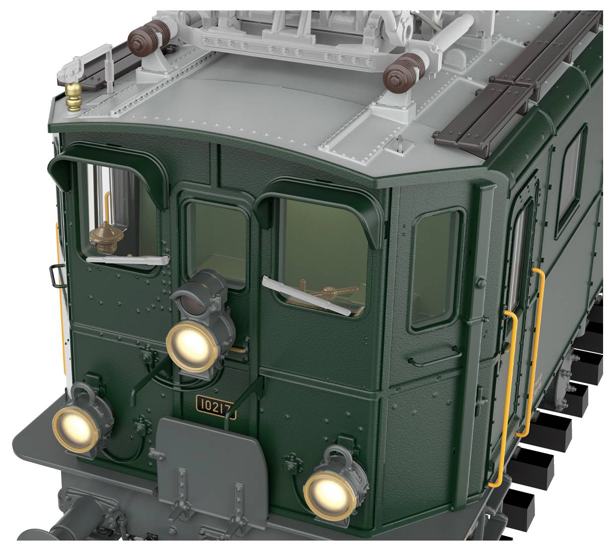 Eine Nahaufnahme der Kabine einer grünen Vintage-Lokomotive mit Lichtern und orangefarbenen Handläufen, die klassische Designelemente zeigt.