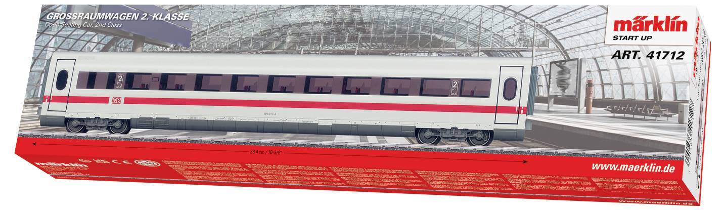 Eine Modellzugverpackung mit einem Wagen der zweiten Klasse mit weißem Körper und rotem Streifen, dargestellt vor einer Kulisse eines Bahnhofs.