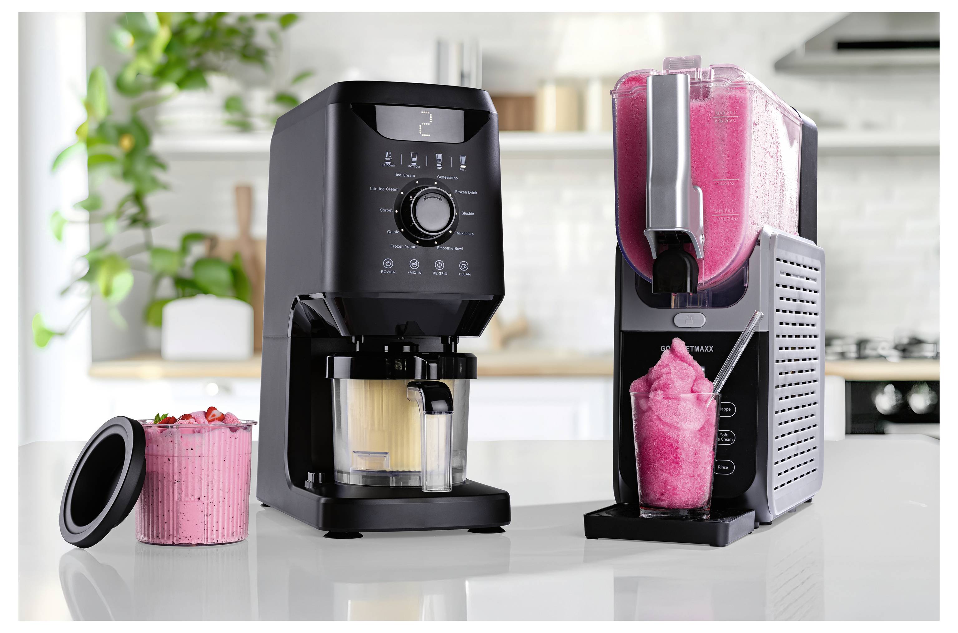 Zwei schwarze Geräte: eine Kaffeemaschine mit einer Tasse darunter und eine Eismaschine, die rosafarbenes Eis ausgibt, auf einer Küchenarbeitsplatte.