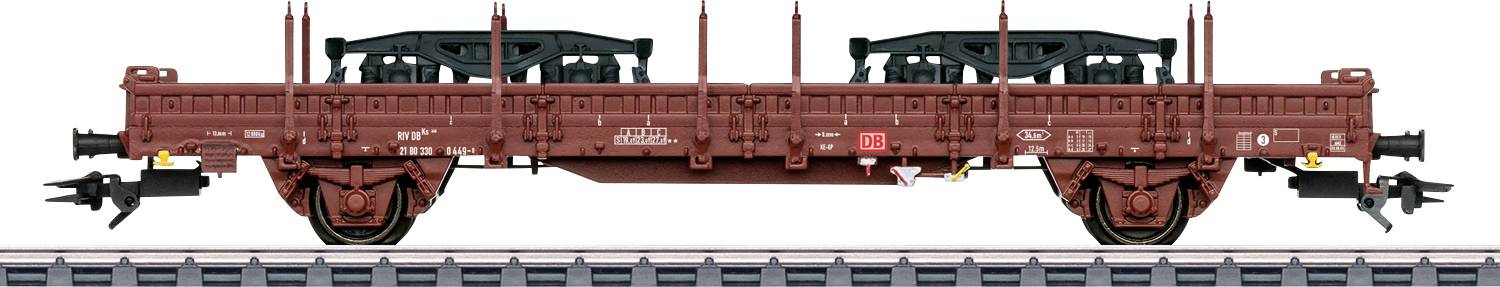 Güterzug mit Flachbettwaggon, der große schwarze Fahrzeugrahmen auf der Oberseite trägt, auf Eisenbahnschienen aufgestellt.