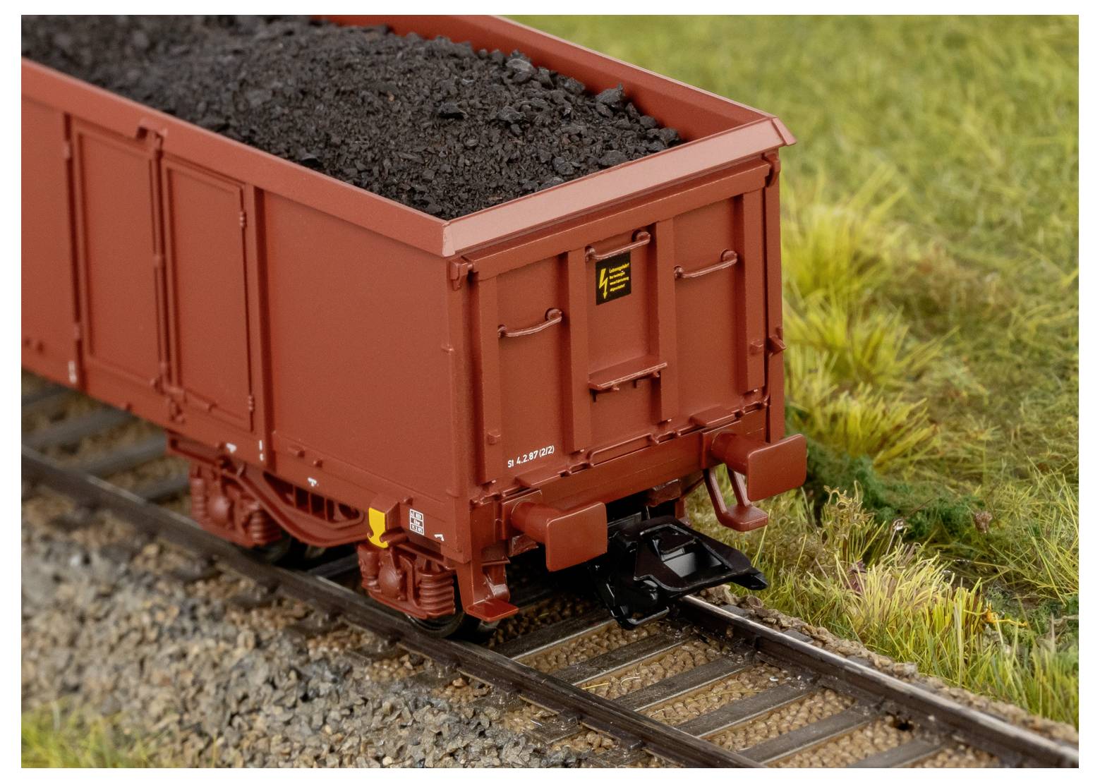 Ein Schlüssel mit vier kreisförmigen Bildern, die einen Schuppen, ein Vorhängeschloss an einem Zaun, ein Türschloss und ein Garagentor zeigen, das Sicherheit für verschiedene Eingänge symbolisiert.