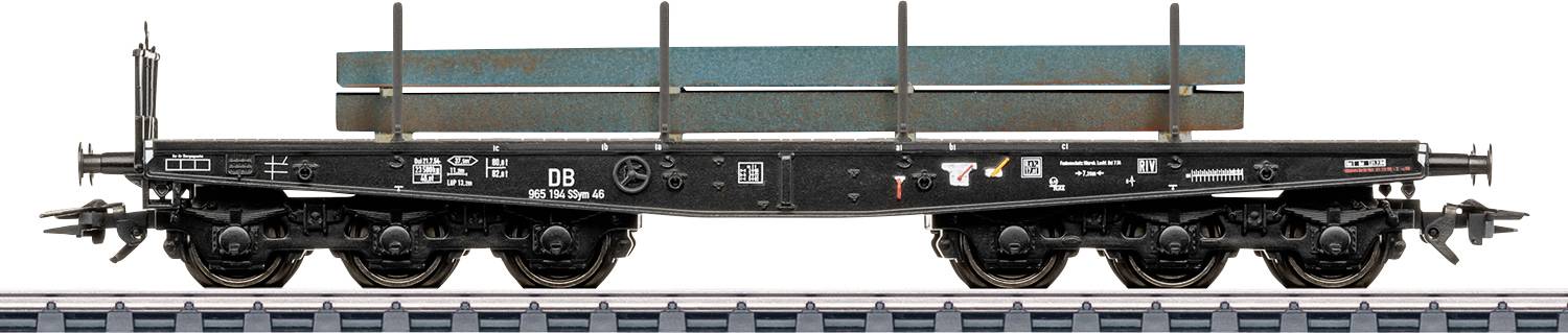 Ein Flachbett-Güterwagen beladen mit langen Stahlträgern, ausgestellt auf einem Gleisabschnitt.