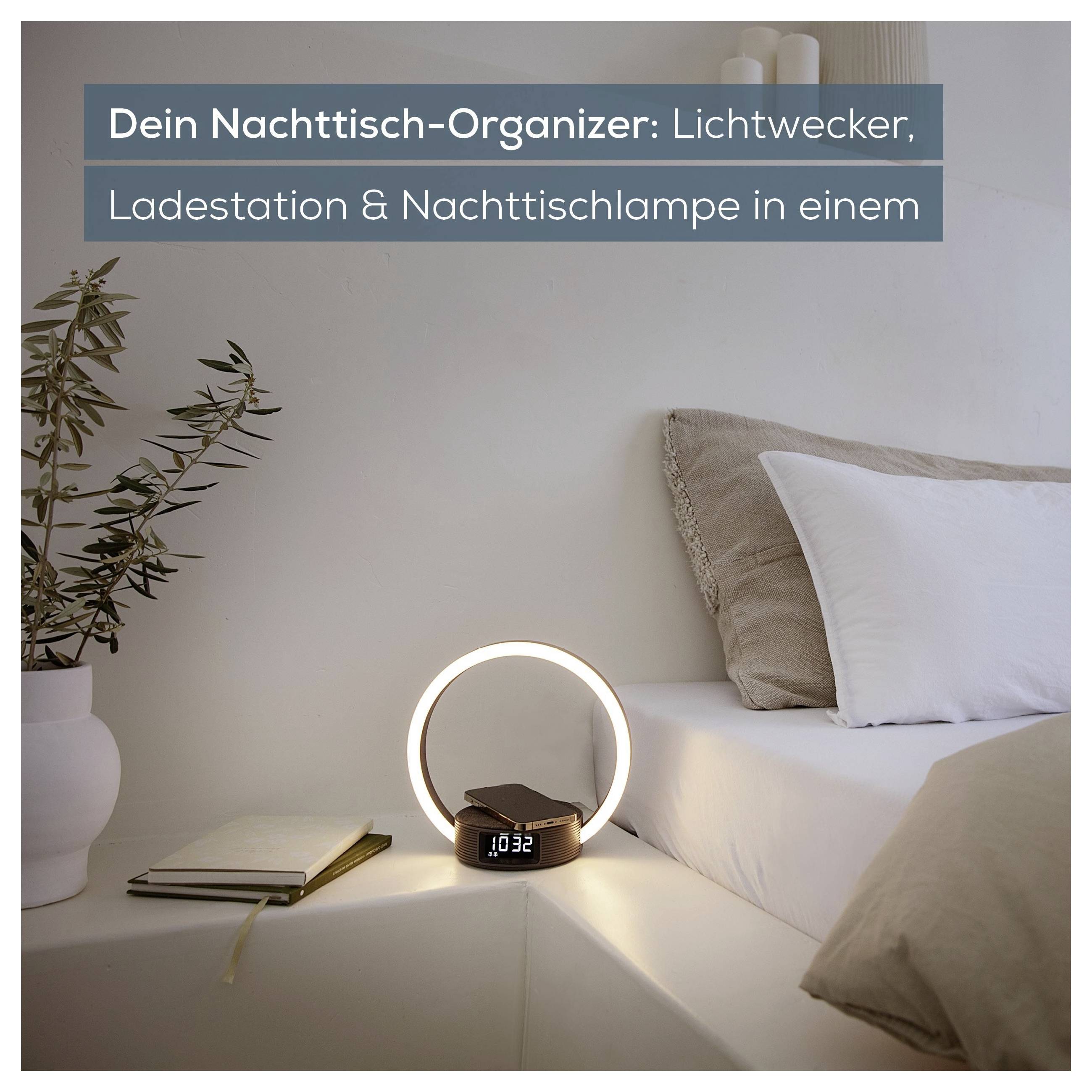 Eine moderne Nachttischeinrichtung mit einer runden Lichtwecker-Uhr, Telefonladestationen und einer Nachttischlampe, die Organisation fördert.