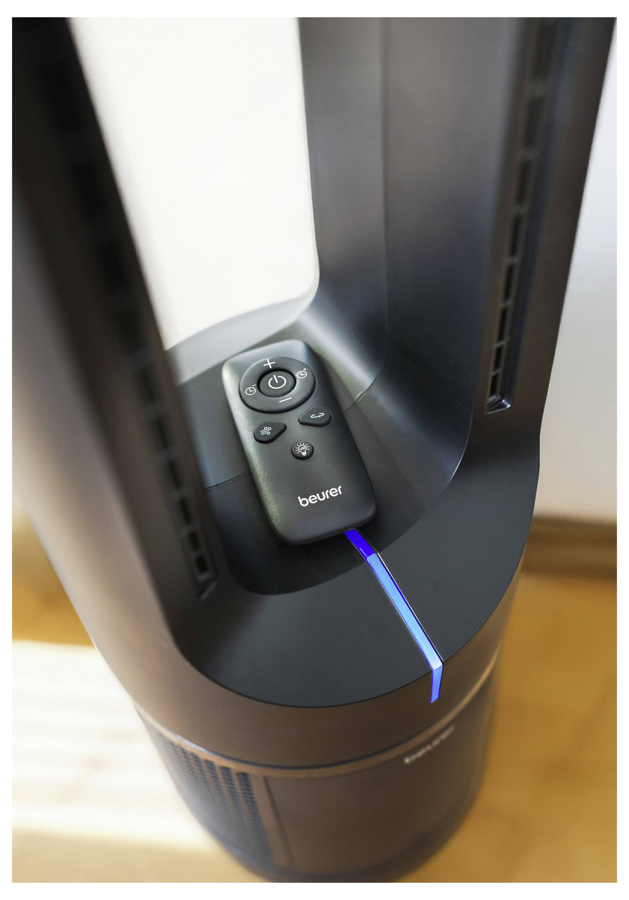 Ein Ventilator ohne Rotorblätter mit einer Fernbedienung oben drauf, mit einem blauen LED-Anzeigelicht auf der Basis; Sonnenlicht wirft einen Schatten.