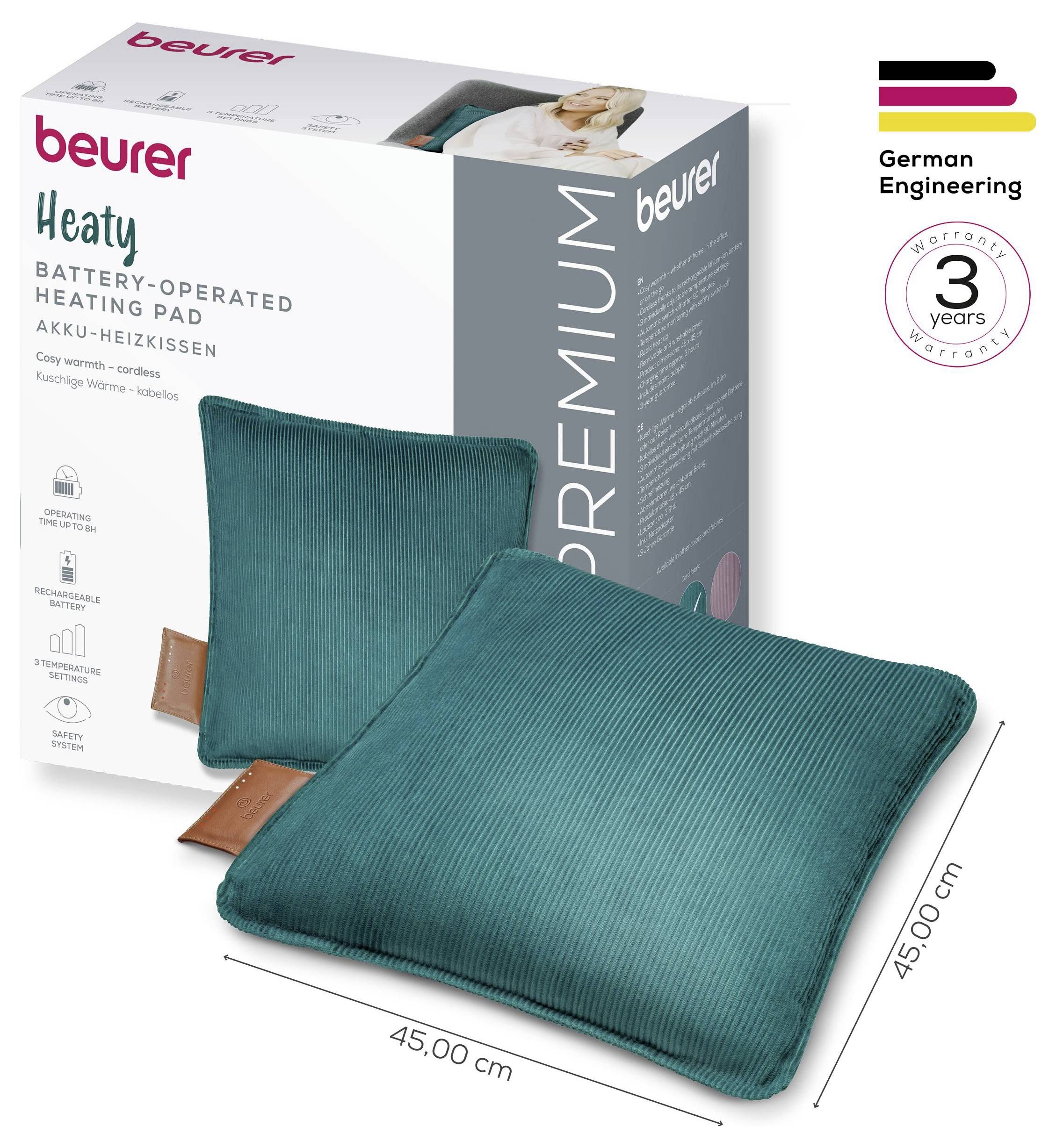 Beurer batteriebetriebenes Wärmekissen, Stoff in Blaugrün, 45x45 cm, neben der Produktverpackung abgebildet. Hebt die 3-jährige Garantie und deutsche Ingenieurkunst hervor.