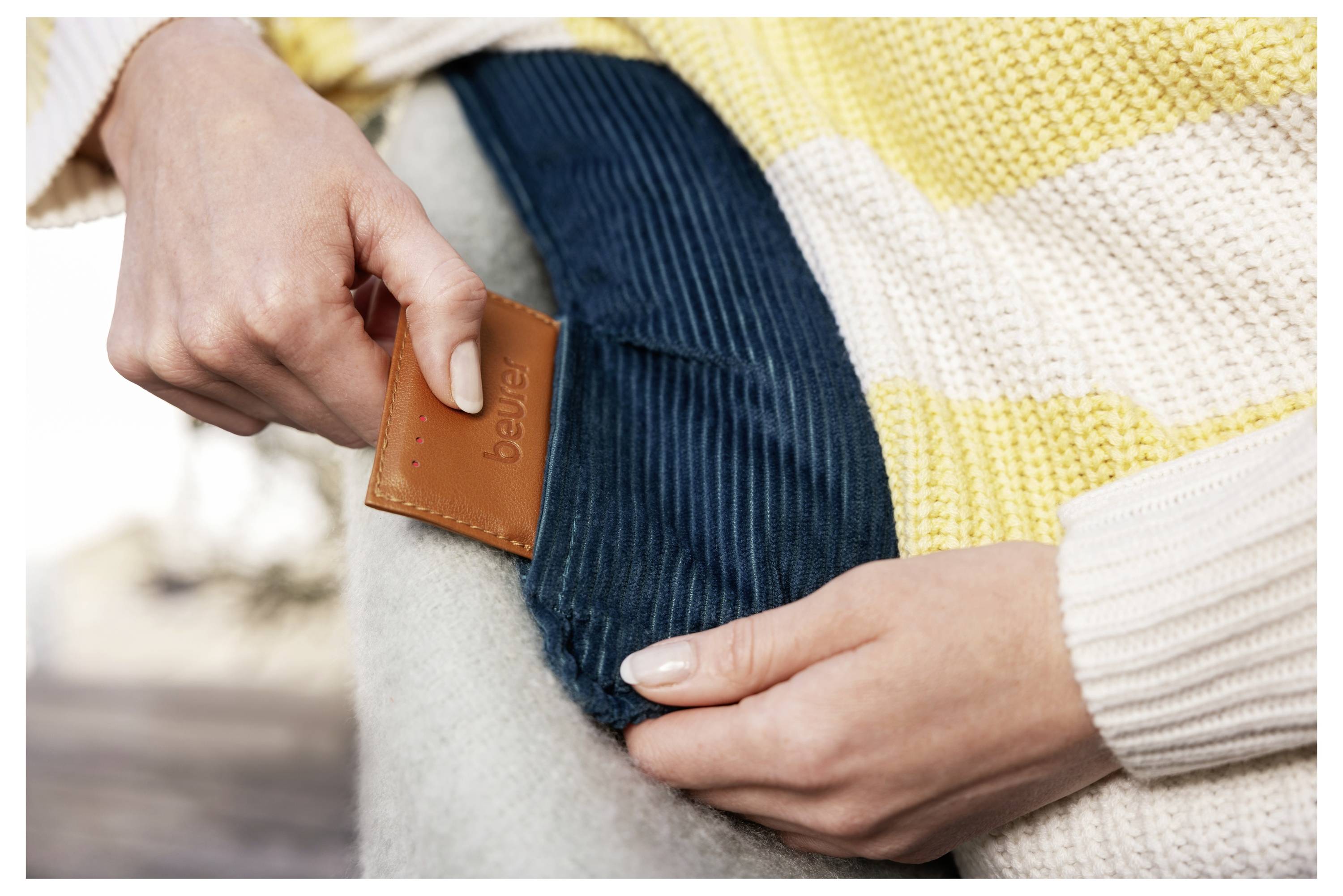 Eine Person legt eine braune Lederkarte mit der Bezeichnung „bewear