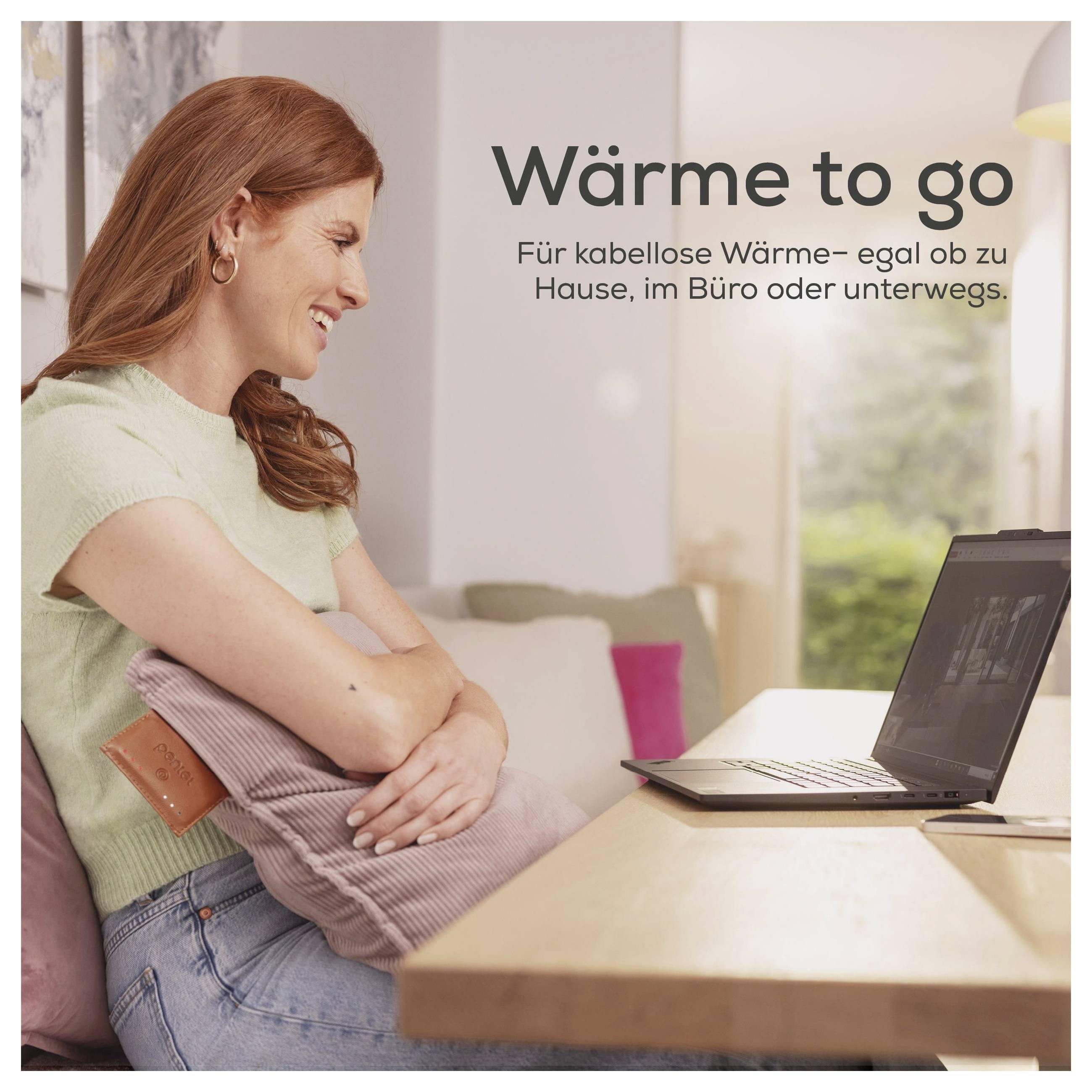 Eine Frau sitzt auf einem Sofa, hält ein Kissen und lächelt auf einen Laptop auf einem Tisch. Der Text im Bild lautet „Wärme to go
