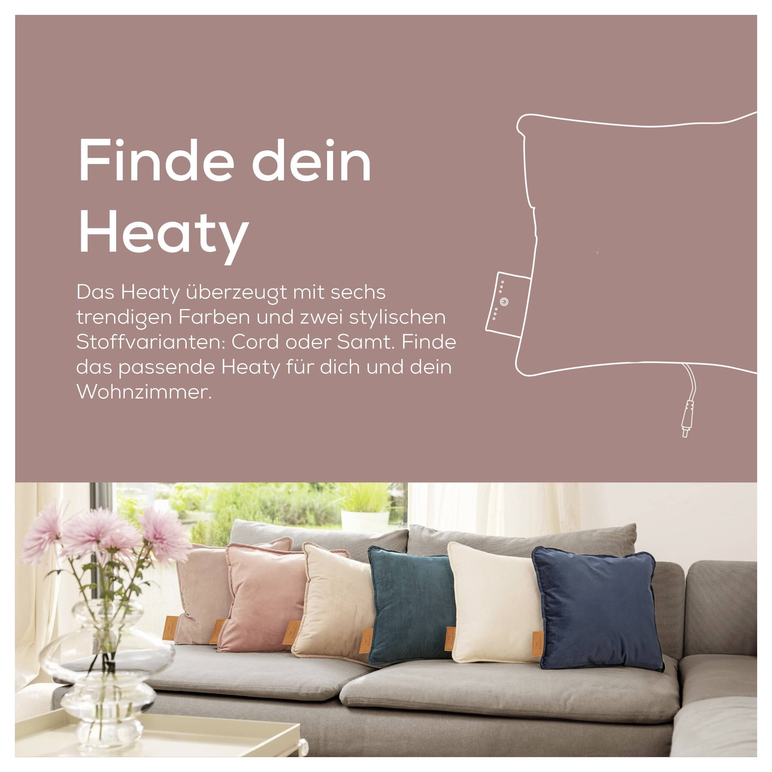Ein Sofa mit bunten Kissen in einem gemütlichen Wohnzimmer. Der Text lautet „Finde dein Heaty