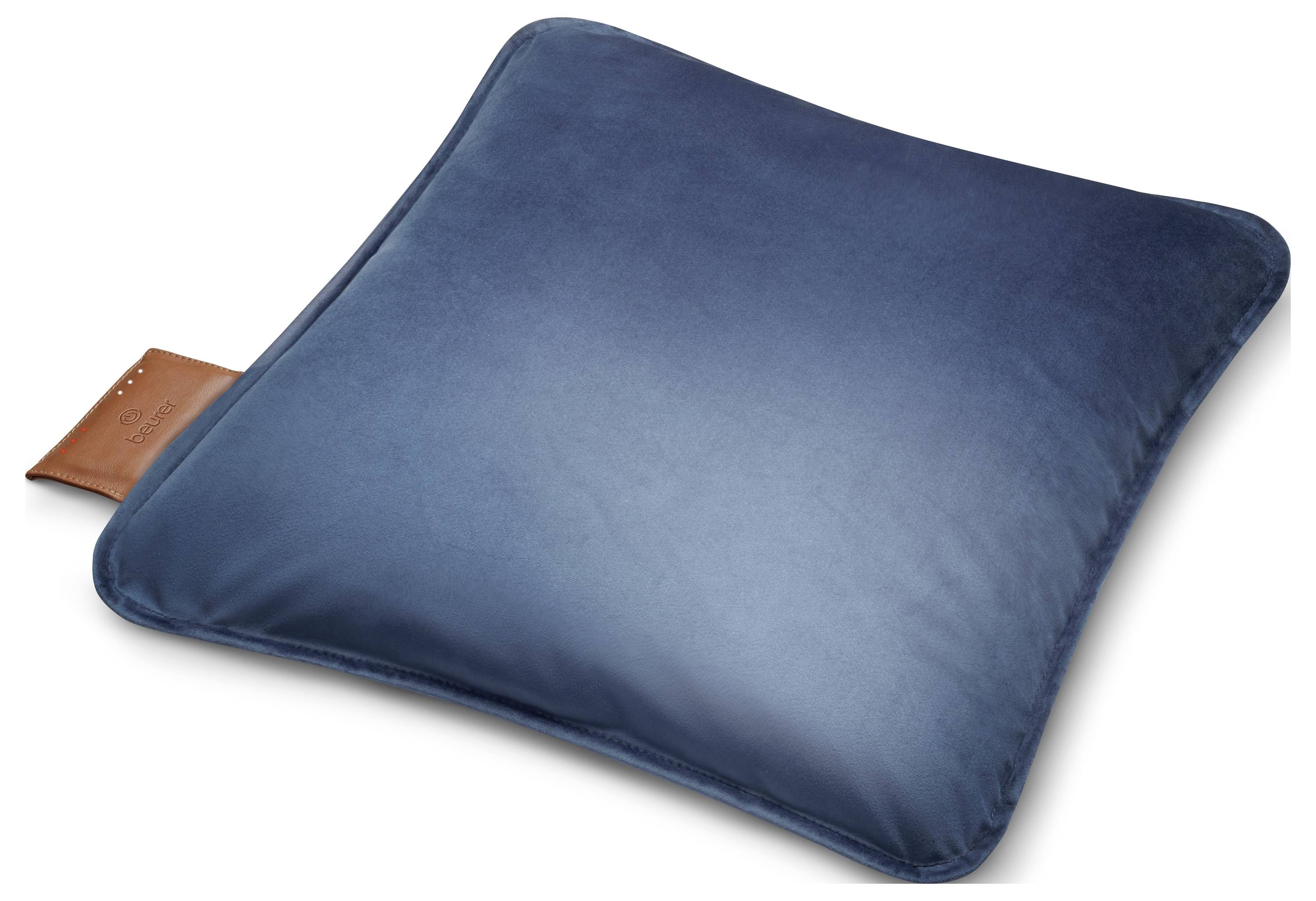 Ein blaues Samtkissen mit einem kleinen braunen Lederetikett an der Seite, auf weißem Hintergrund platziert.