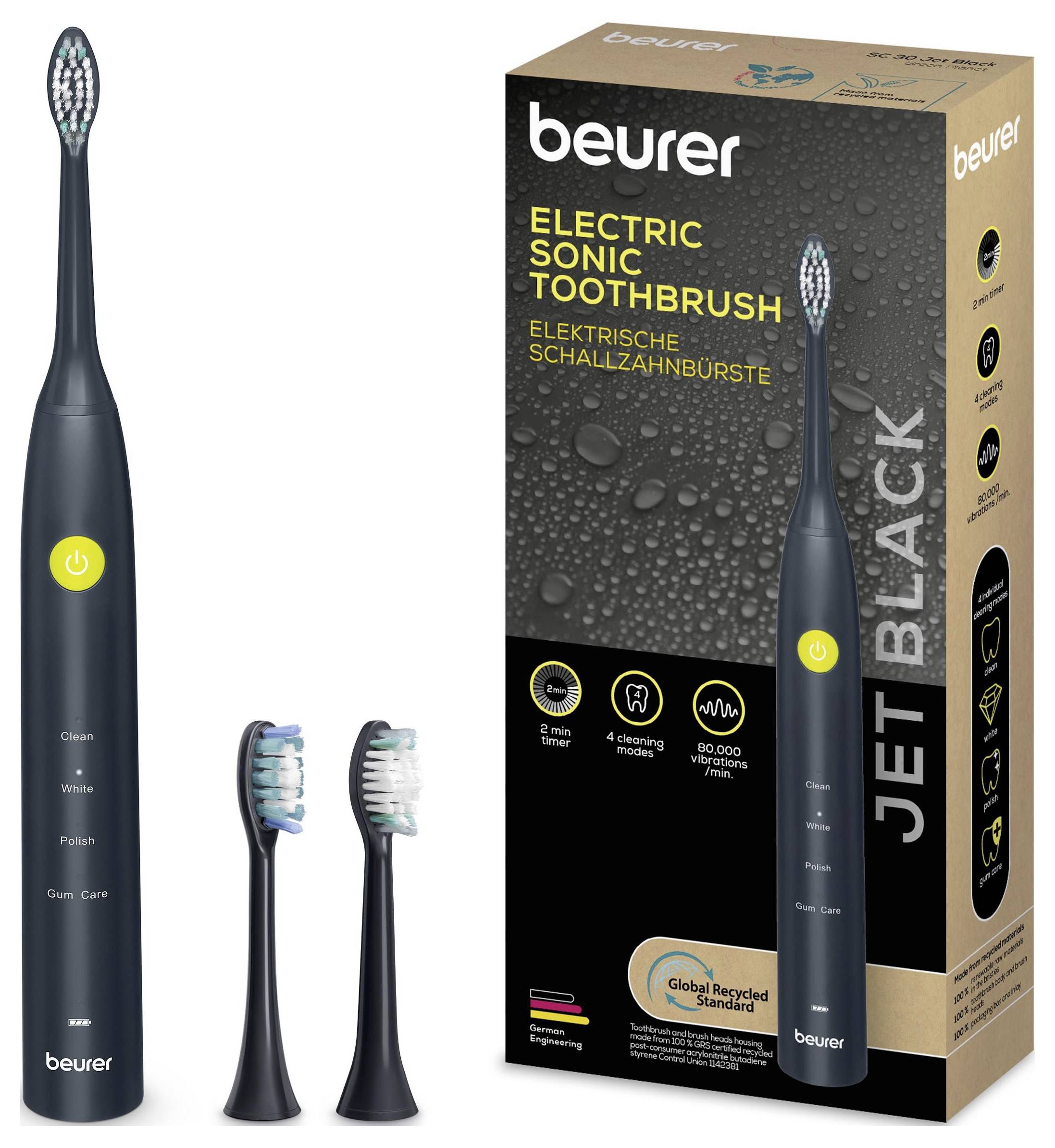 Eine elektrische Schallzahnbürste mit zwei Ersatzköpfen wird neben ihrer Verpackung mit der Bezeichnung 
