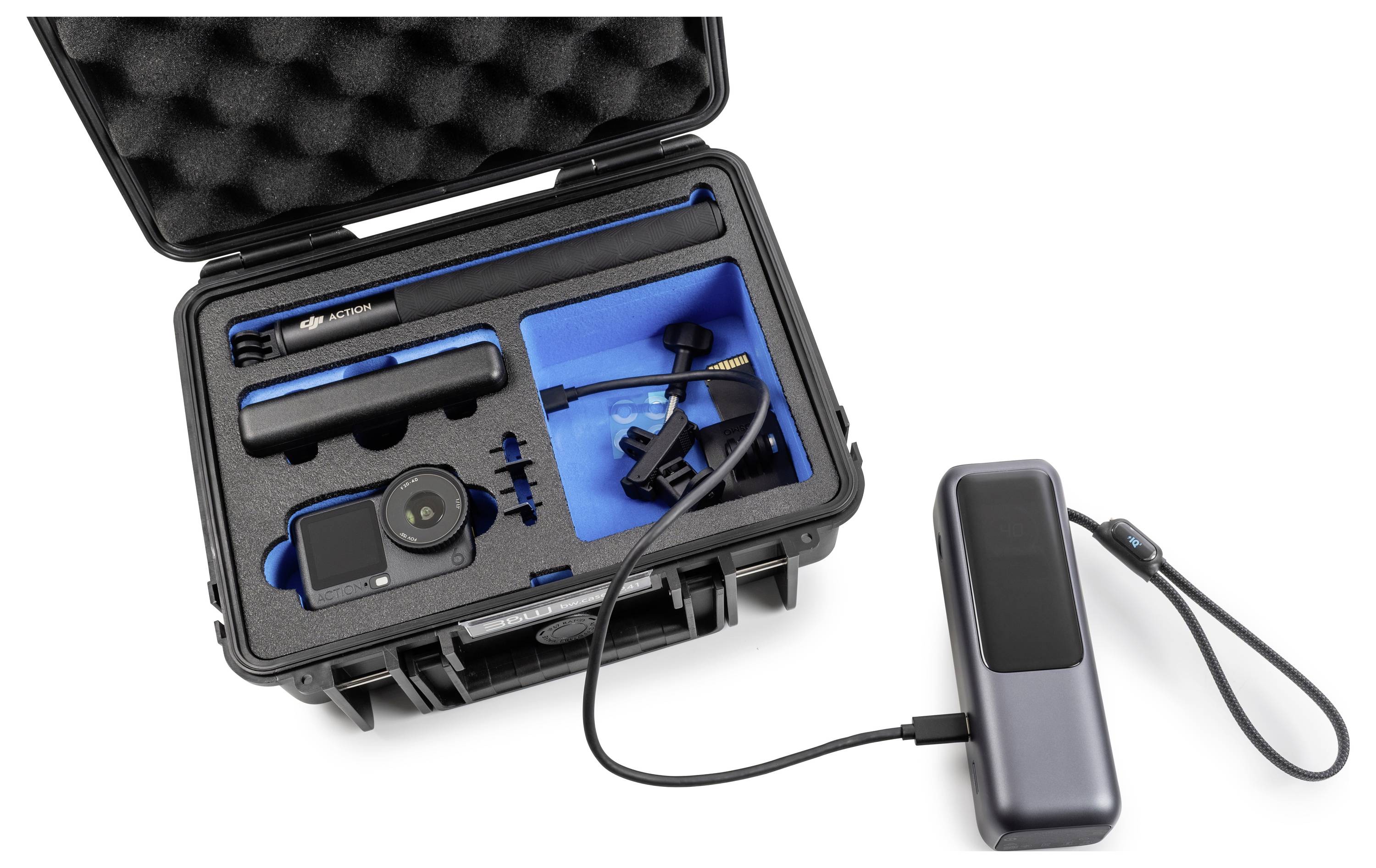 Ein Schutzkoffer mit einer Kamera und Zubehör, einschließlich Objektiv, Mikrofon und Akku, organisiert in benutzerdefinierten Schaumstoff-Einsätzen.