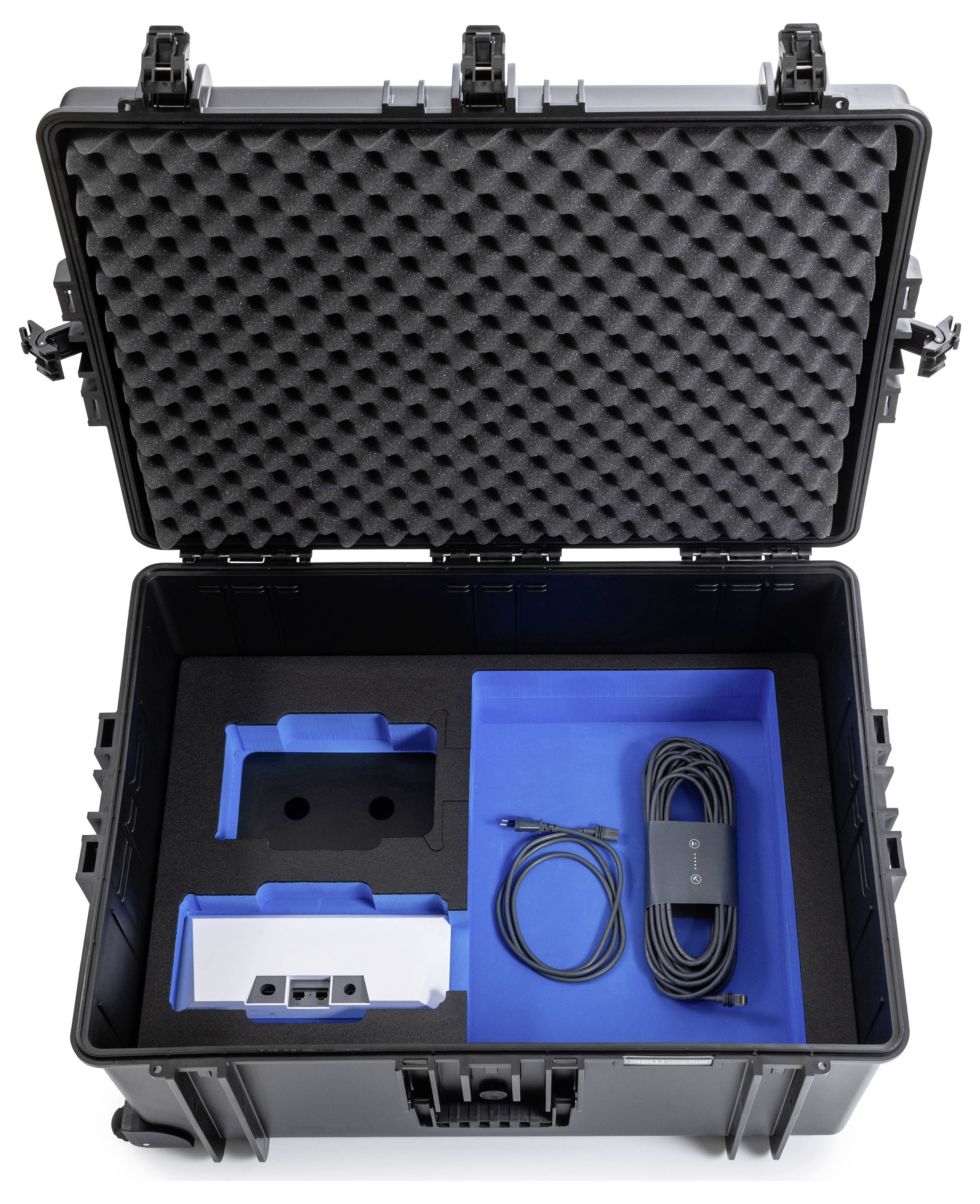 Offenes schwarzes Transportetui mit einem Netzteil und Kabel, ordentlich in Schaumstoff-Fächern organisiert.