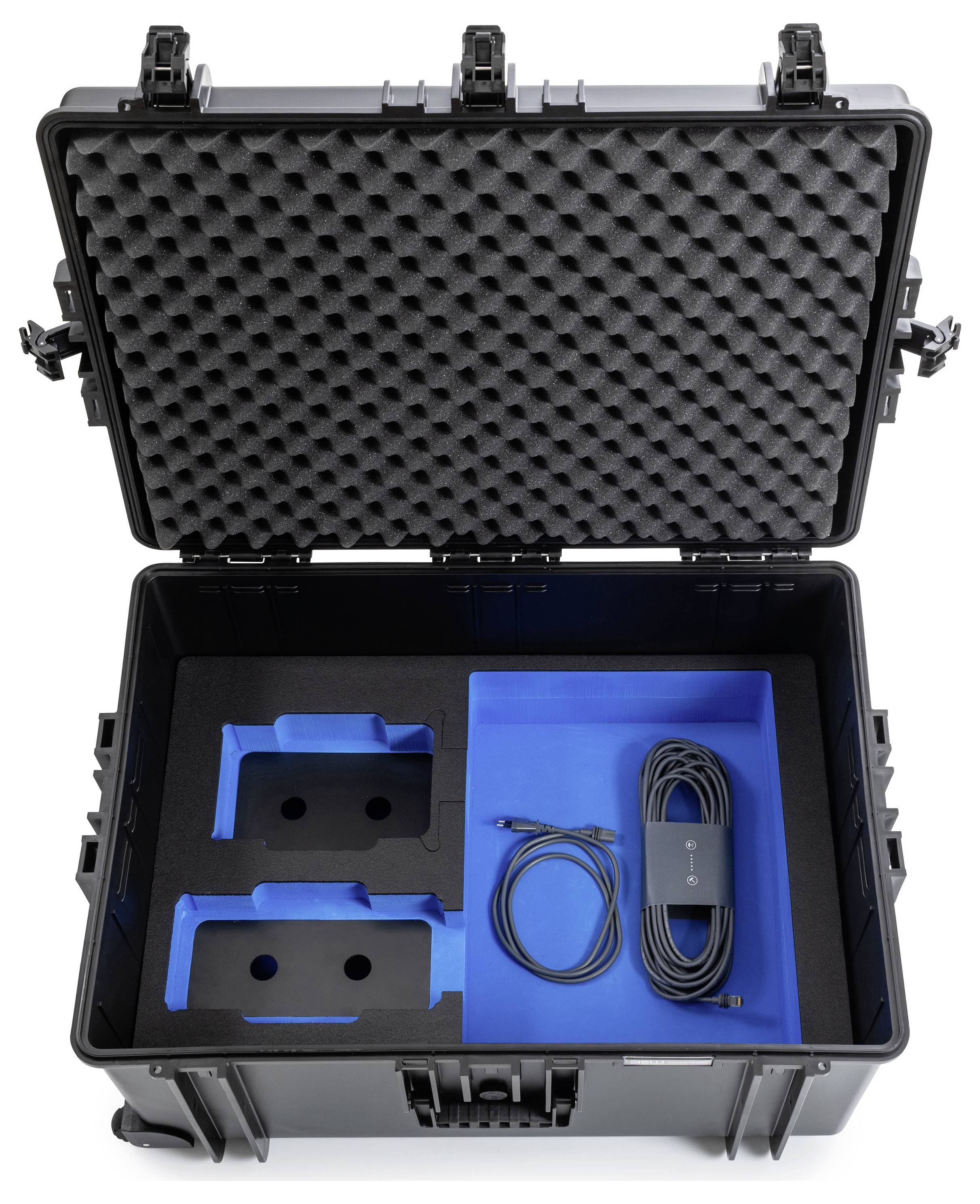 Offener schwarzer Transportkoffer mit Schaumstoffpolsterung enthält zwei blaue Einsätze und ein aufgerolltes Kabel.