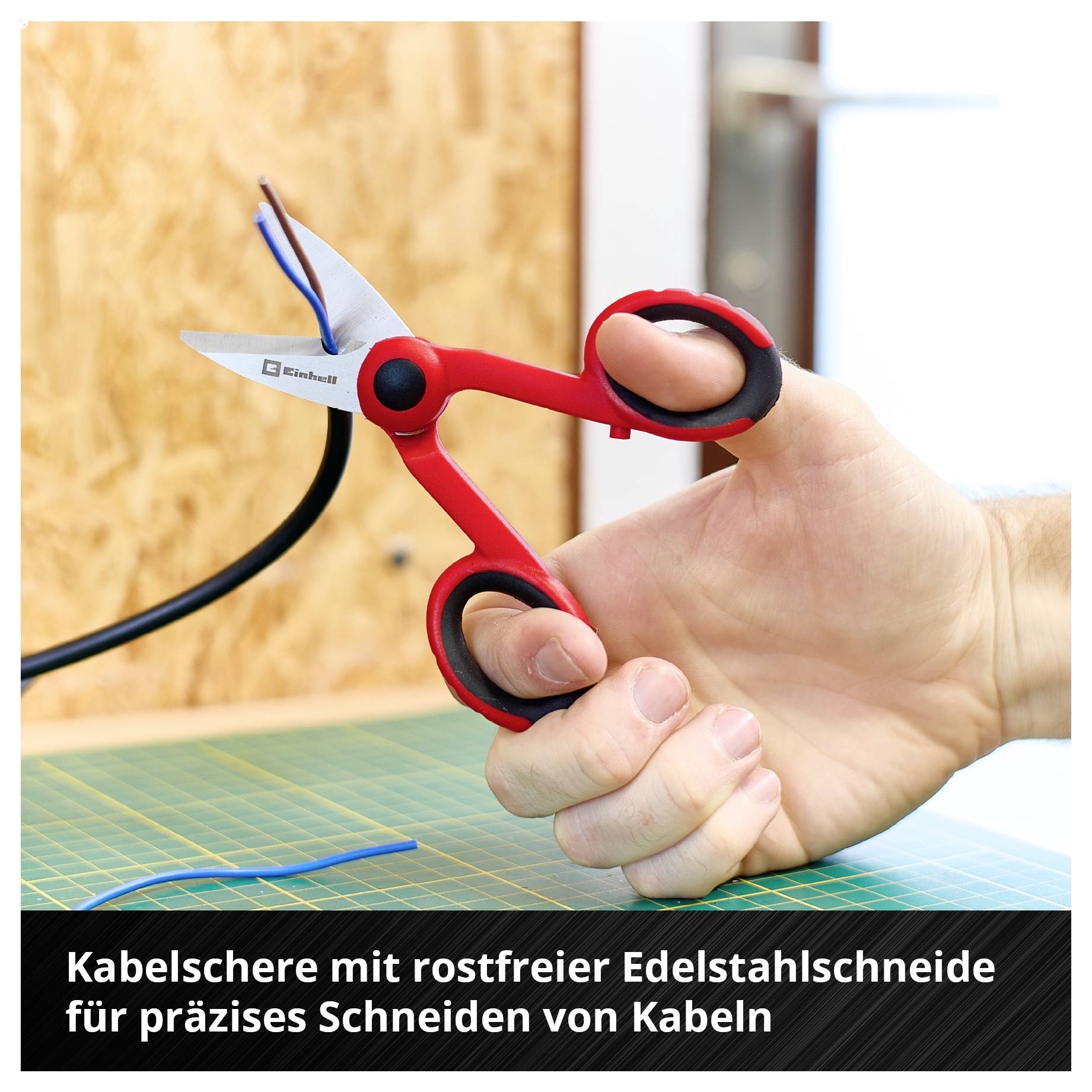 Hand hält rote Kabelschere, schneidet Kabel auf grünem Tisch. Text: 'Kabelschere mit rostfreier Edelstahlschneide für präzises Schneiden von Kabeln'.