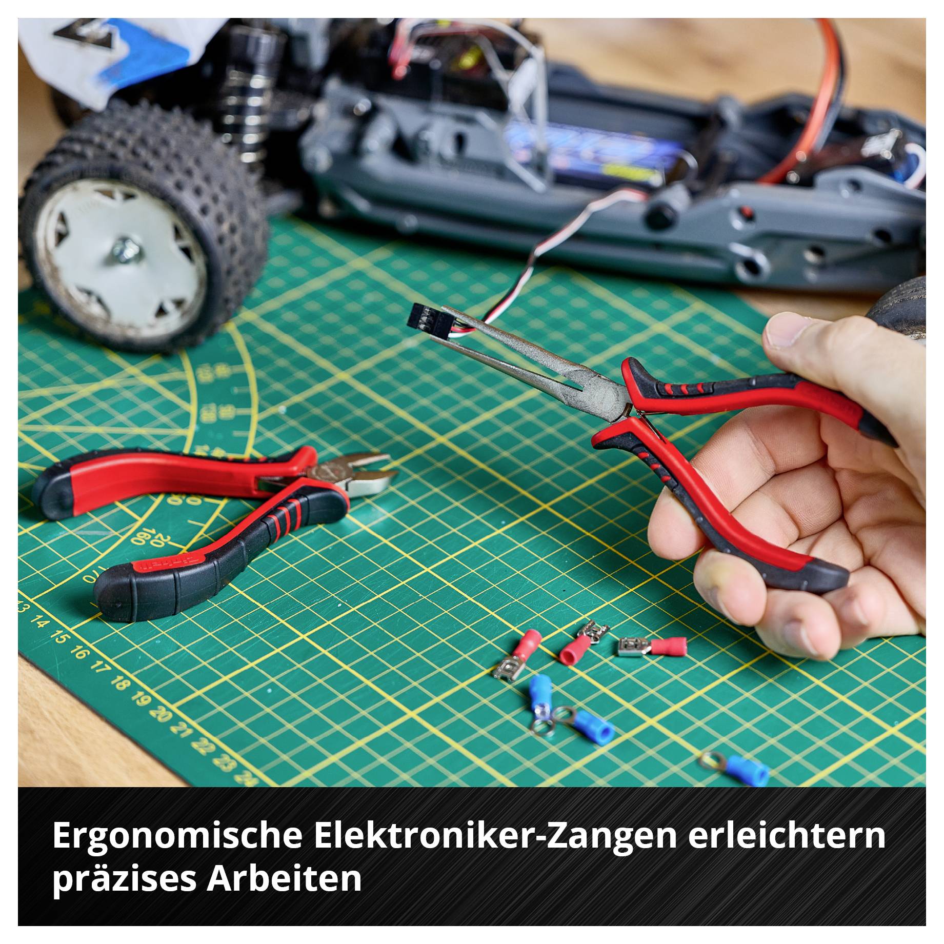 Werkbank mit Modellauto, Elektroniker-Zangen und Kabeln. Beschriftung: 'Ergonomische Elektroniker-Zangen erleichtern präzises Arbeiten'.