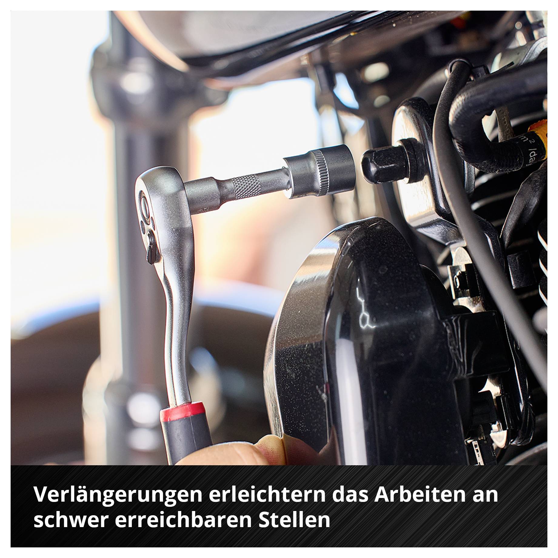 Eine Ratsche mit Verlängerung wird an einem schwer erreichbaren Teil eines Motors verwendet. Text: 'Verlängerungen erleichtern das Arbeiten an schwer erreichbaren Stellen'.