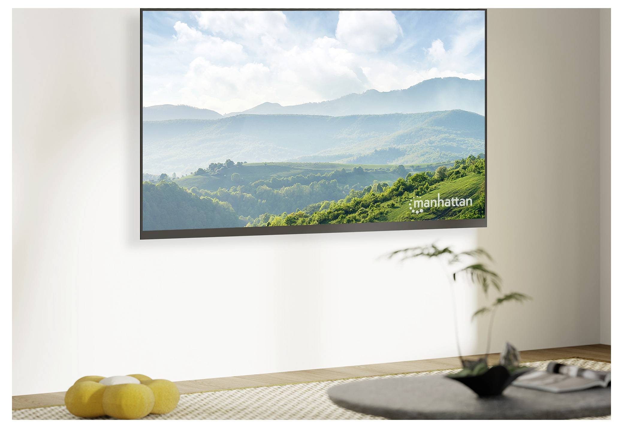 Ein Flachbildfernseher zeigt eine malerische Berglandschaft mit üppiger Grünfläche.