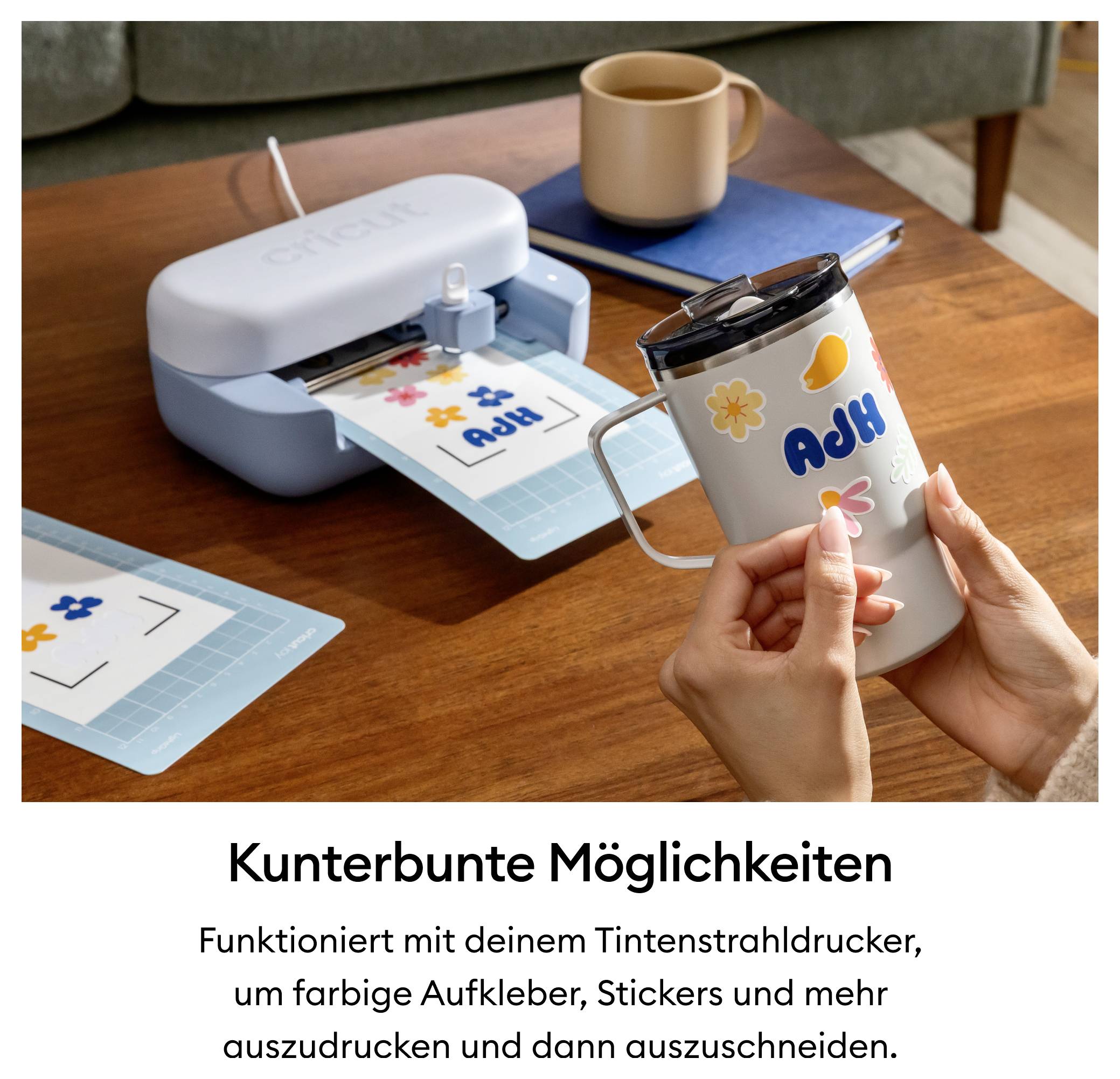 Eine Person verziert eine Thermoskanne mit farbigen Aufklebern aus einem Schneidegerät.