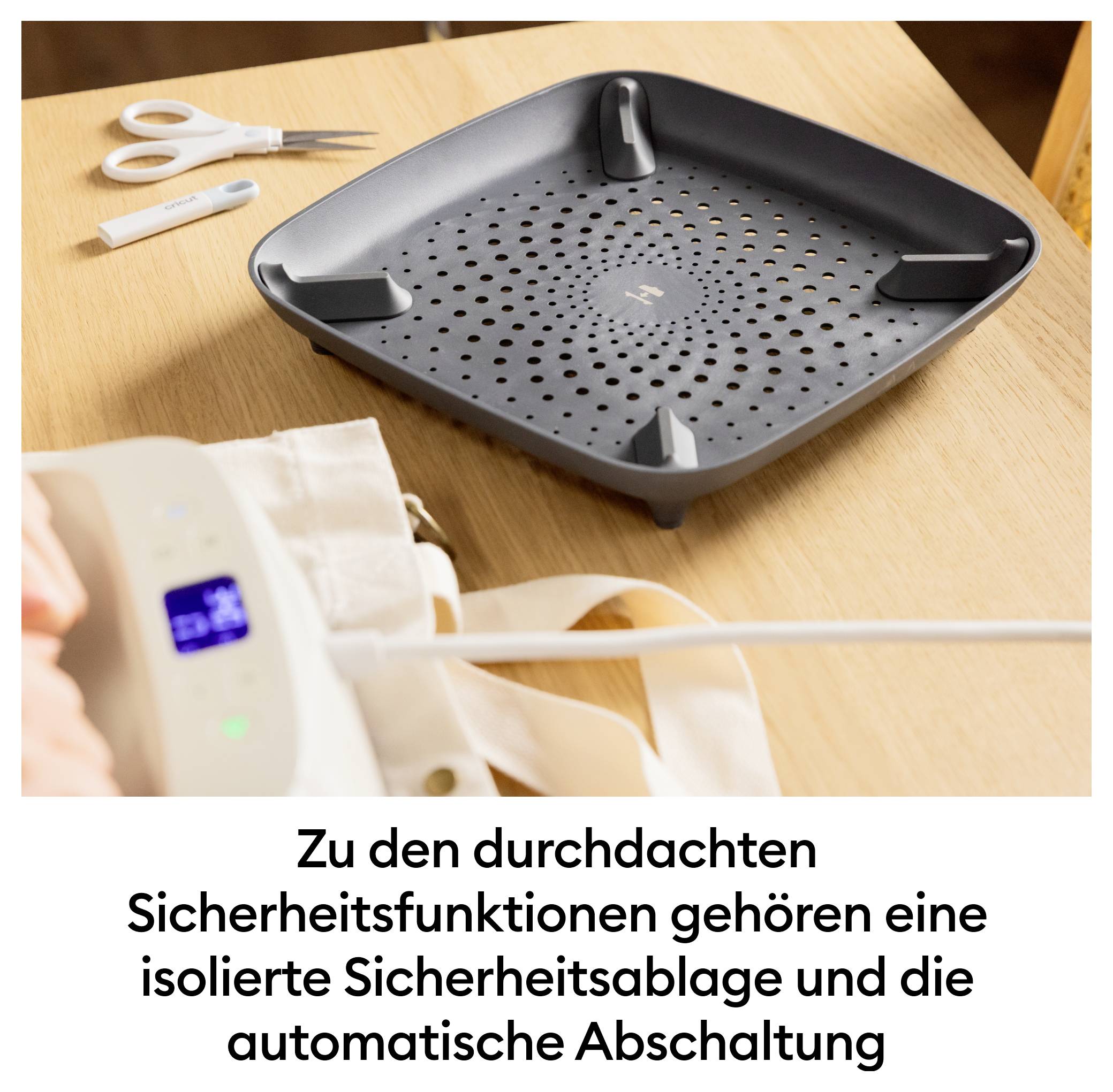 Eine schwarze Sicherheitsablage mit Löchern auf einem Tisch neben einer Schere. Text beschreibt Funktionen der automatischen Abschaltung.