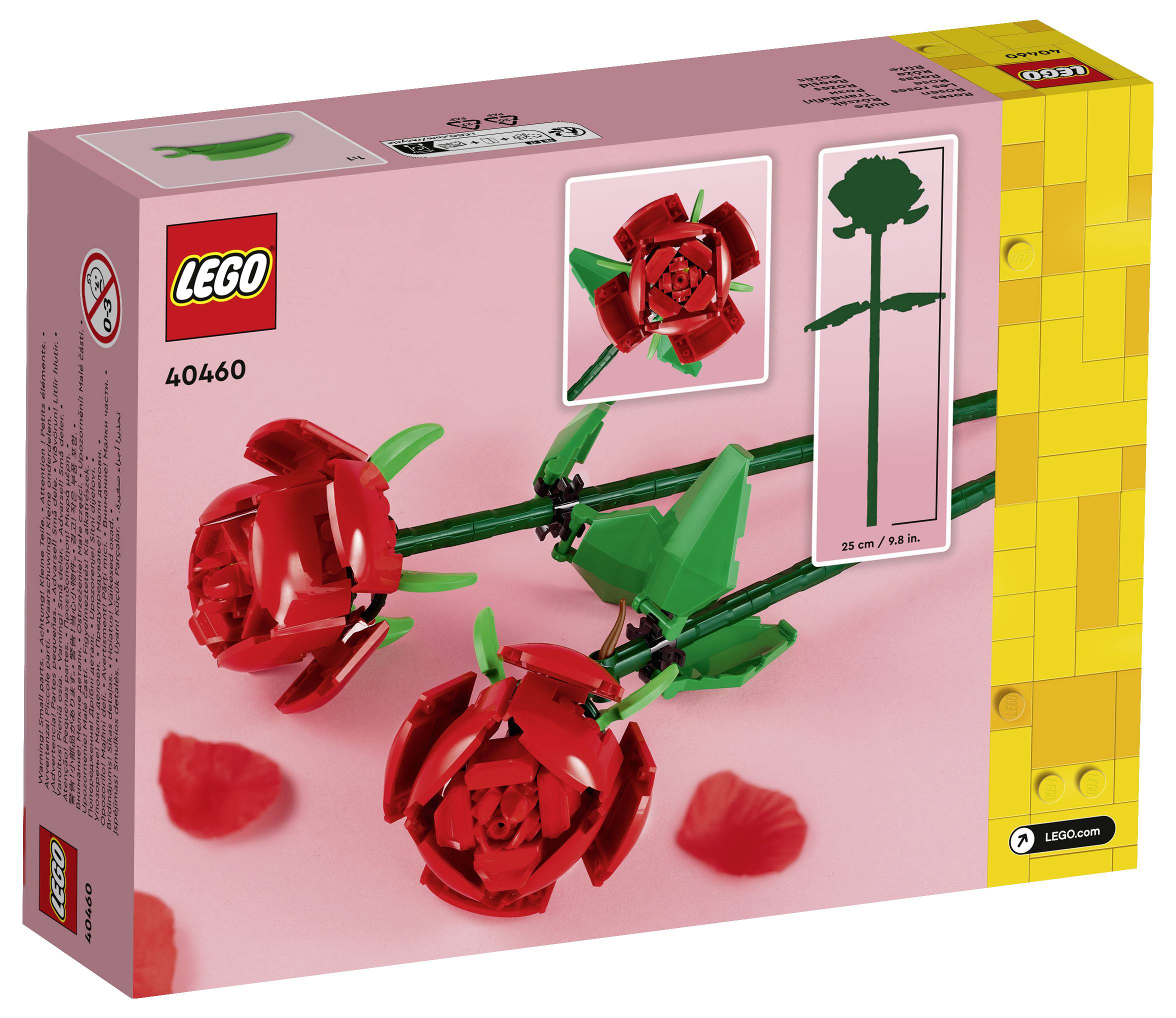 Schachtel des LEGO-Sets 40460 mit roten Rosen aus LEGO-Steinen, ausgestellt auf einem rosa Hintergrund mit verstreuten Blütenblättern.