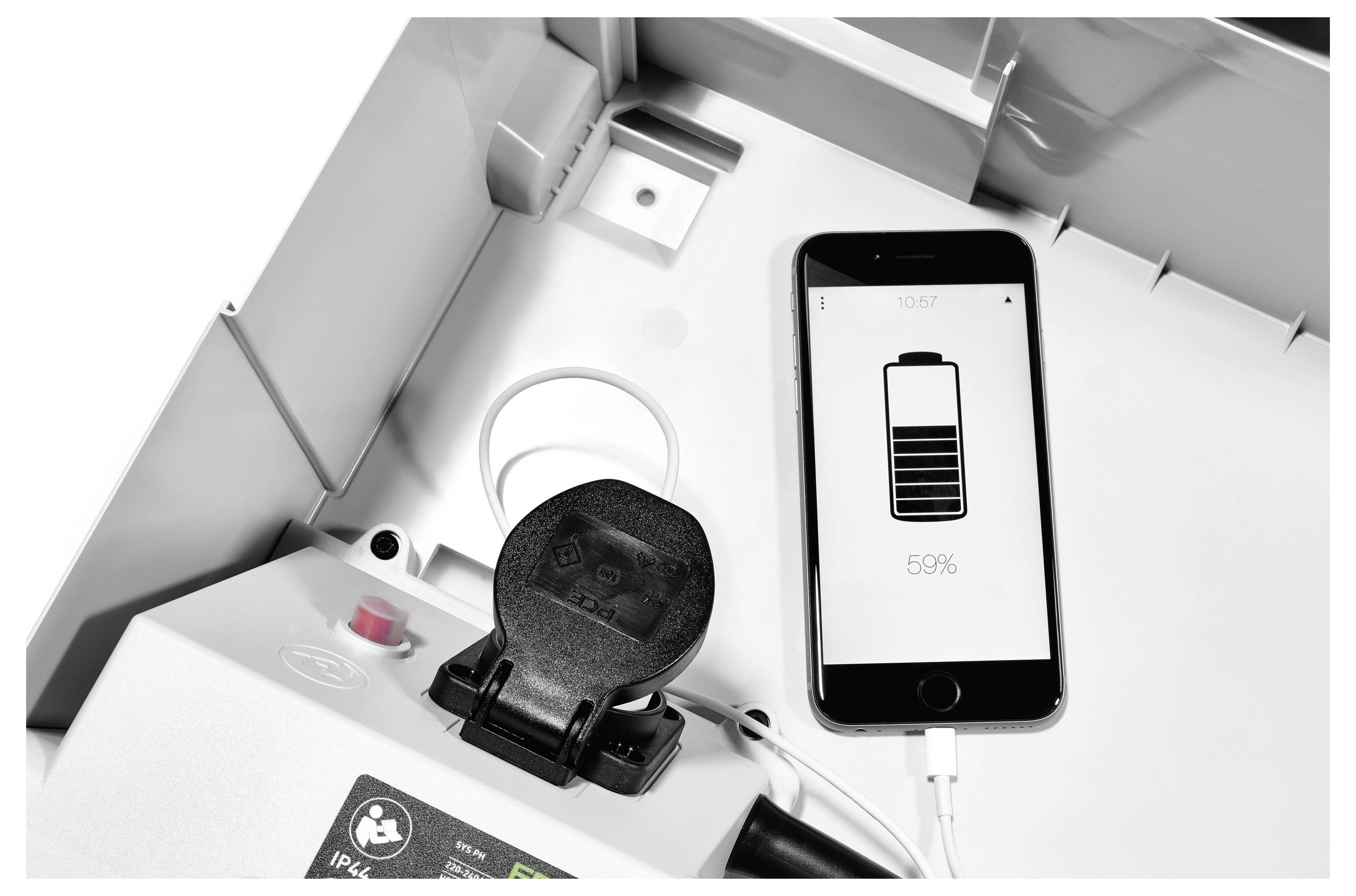 Ein Smartphone, das auf einem Gerät aufgeladen wird, wobei auf seinem Bildschirm ein Batteriesymbol angezeigt wird, das eine verbleibende Ladung von 55% anzeigt, neben technischer Ausrüstung.