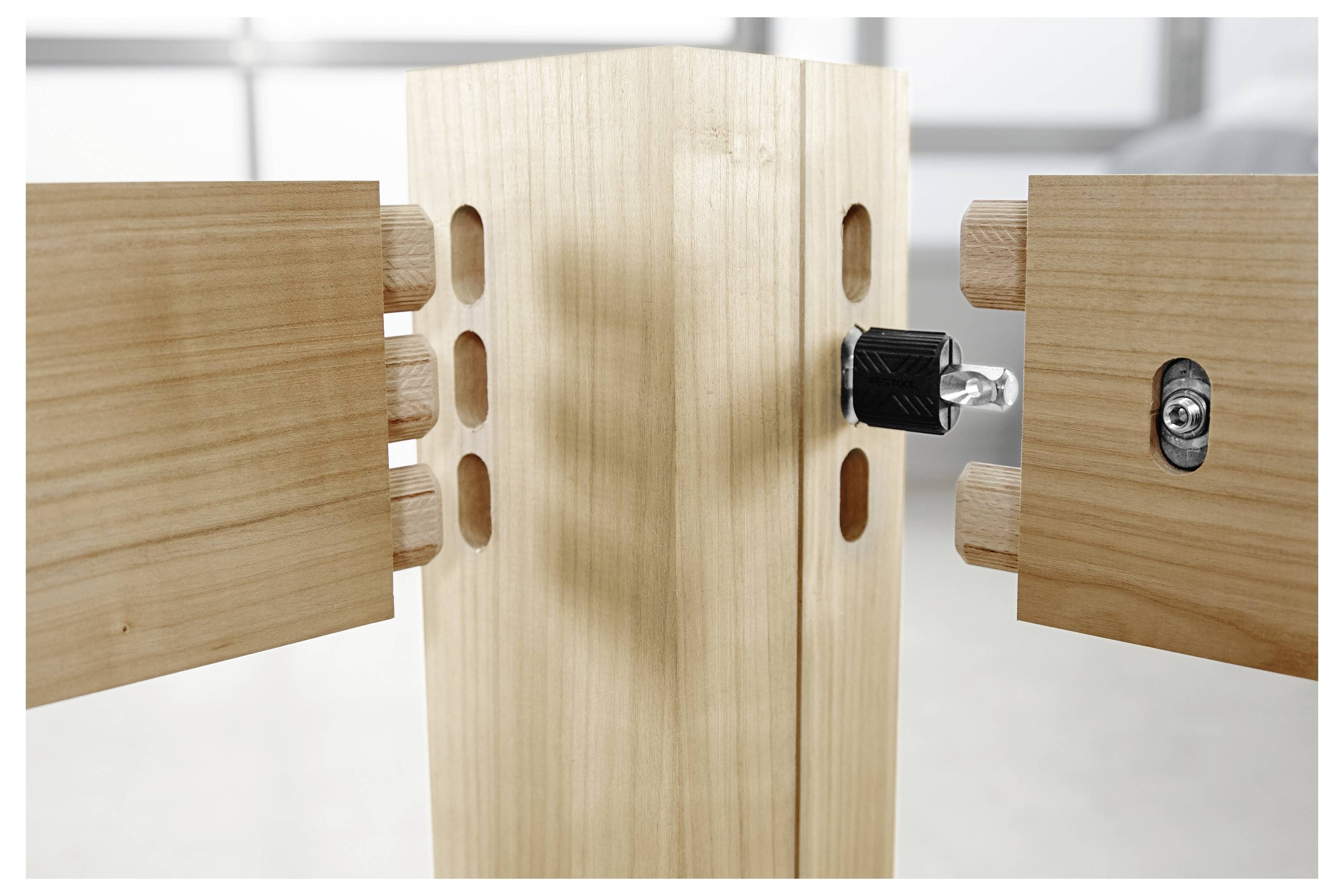 Ein Möbelstück aus Holz wird zusammengebaut, wobei zwei Seitenpaneele mit Dübeln ausgerichtet sind, um sich mit dem zentralen Pfosten zu verbinden.