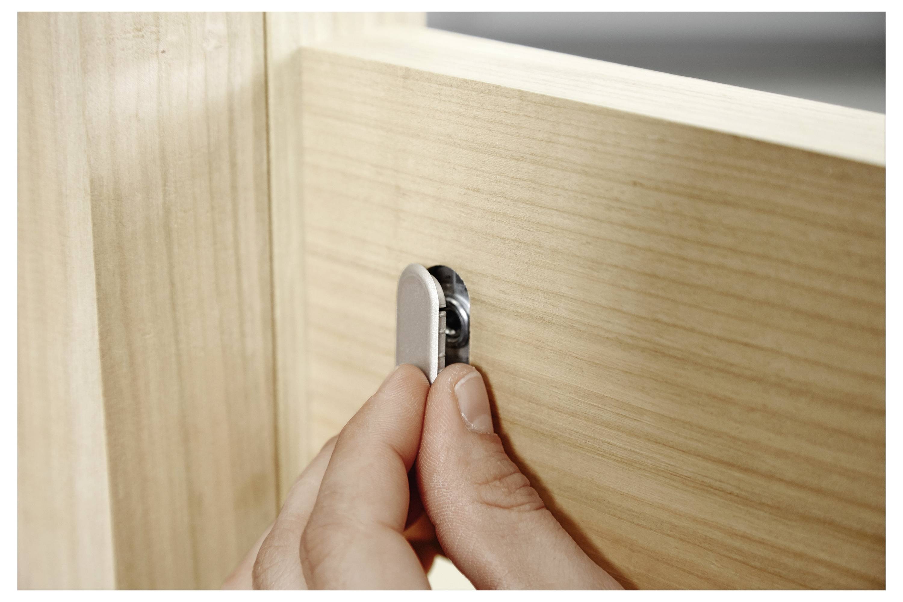 Eine Person bedient einen Festool ETSC 125 Akku-Schleifer auf einer Holzoberfläche, wobei das kompakte Design und die Benutzerfreundlichkeit hervorgehoben werden.