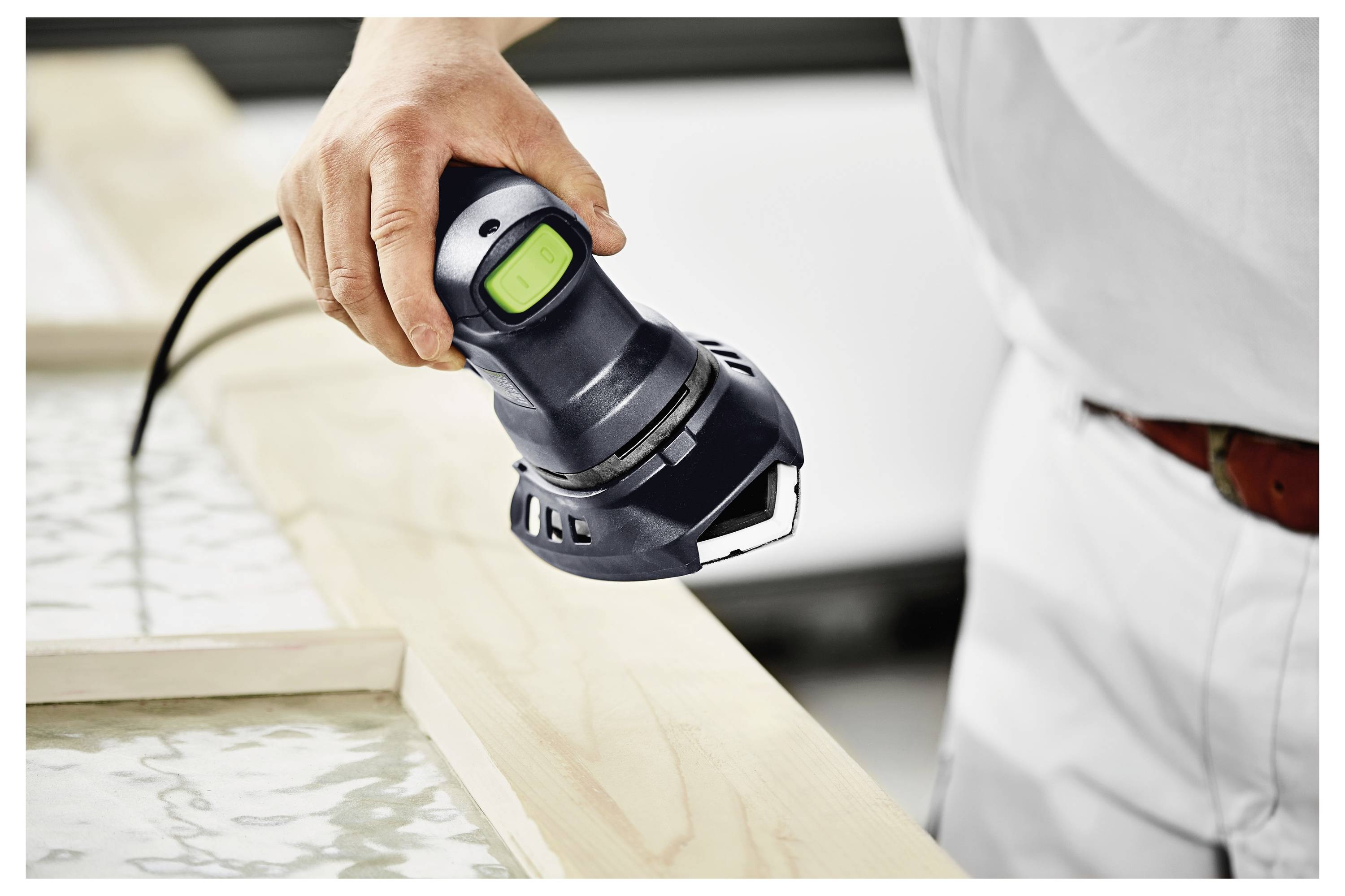 Eine Person in einem grauen Pullover hält einen transparenten Plastikbehälter oder eine Plastiktüte. Der Fokus liegt auf der Hand und dem Behälter, was auf Packen oder Umzug hindeutet.