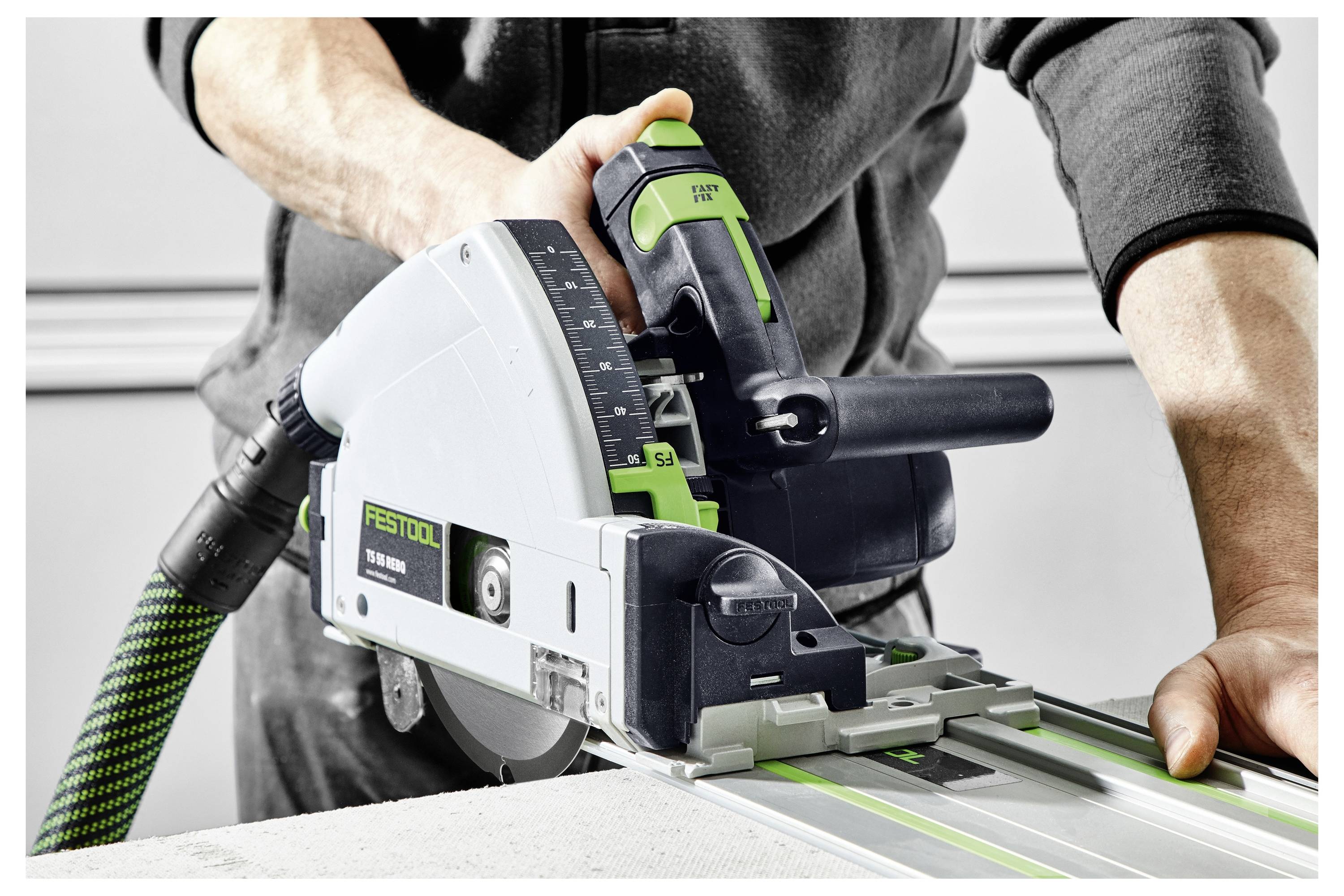Eine Person bedient eine Festool-Schienen-Kreissäge und schneidet ein Materialstück zu, wobei sie Präzision und Kontrolle mit dem Werkzeug demonstriert.