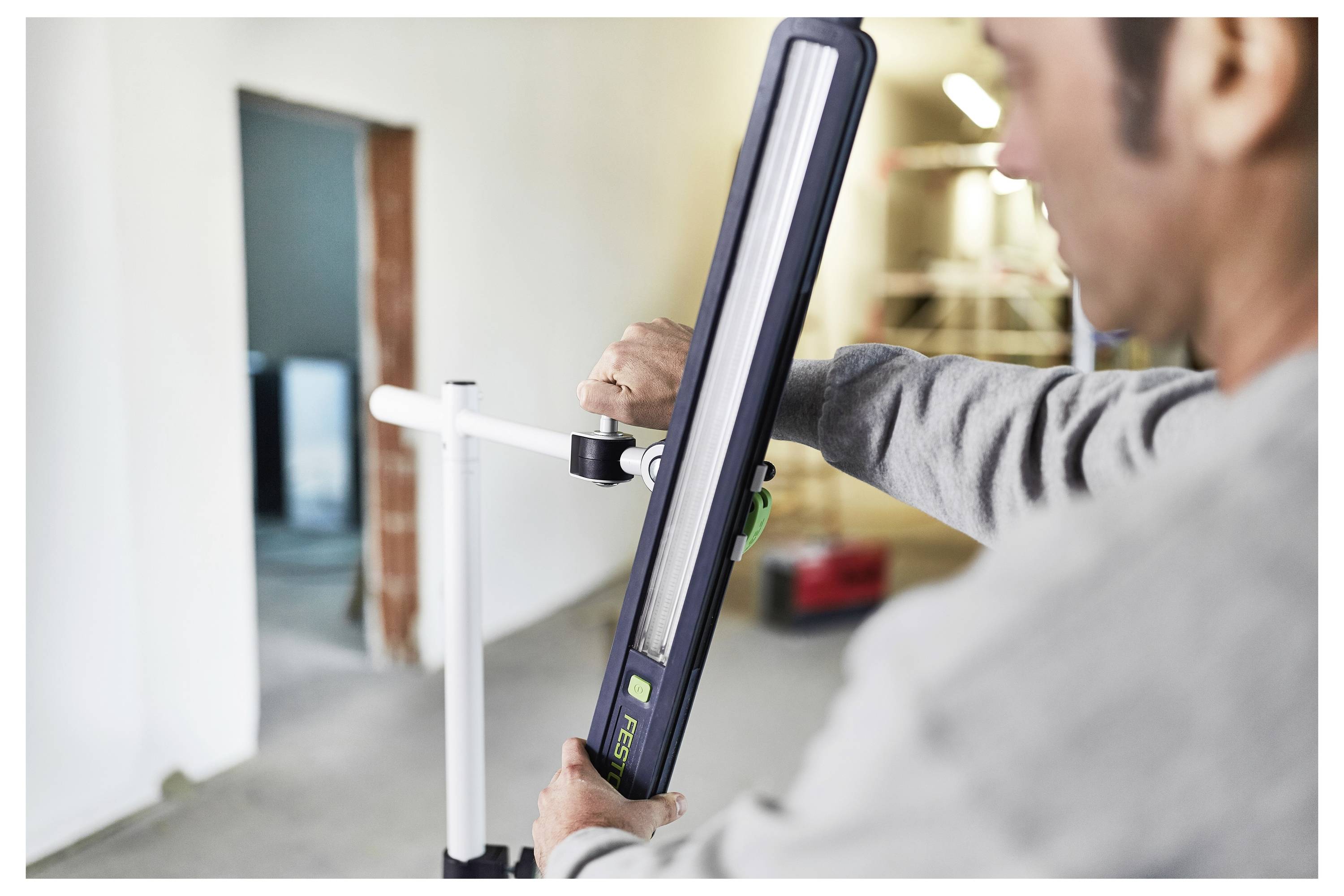 Eine Person benutzt ein Elektrowerkzeug, um eine Holzfusskantenkante zu schneiden oder anzupassen, was Heimwerker- oder Renovierungsarbeiten demonstriert.