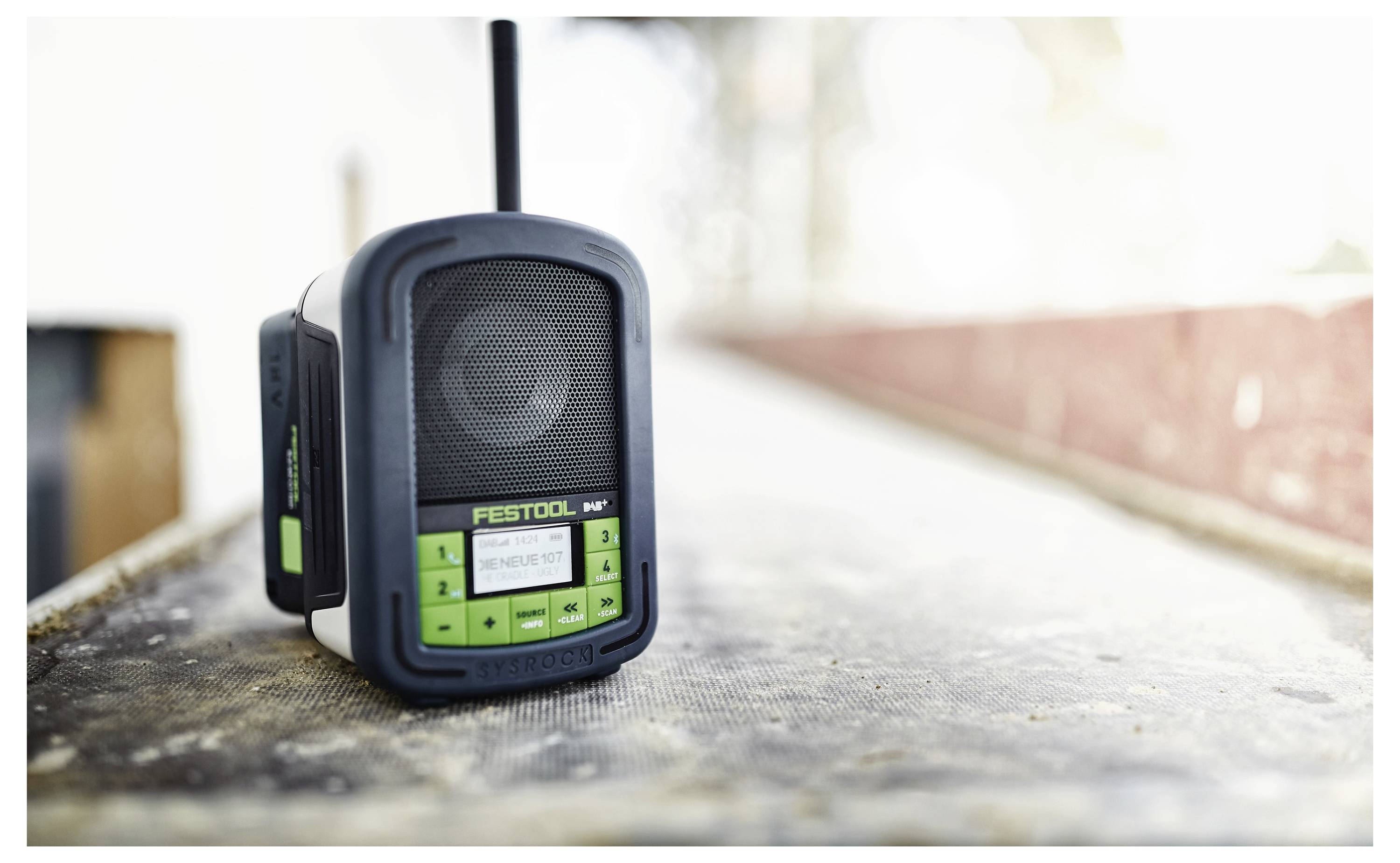 Ein tragbares Festool-Radio auf einer Werkbank platziert, mit klaren Bedienungselementen und einer Antenne, was die Einsatzbereitschaft auf der Baustelle andeutet.