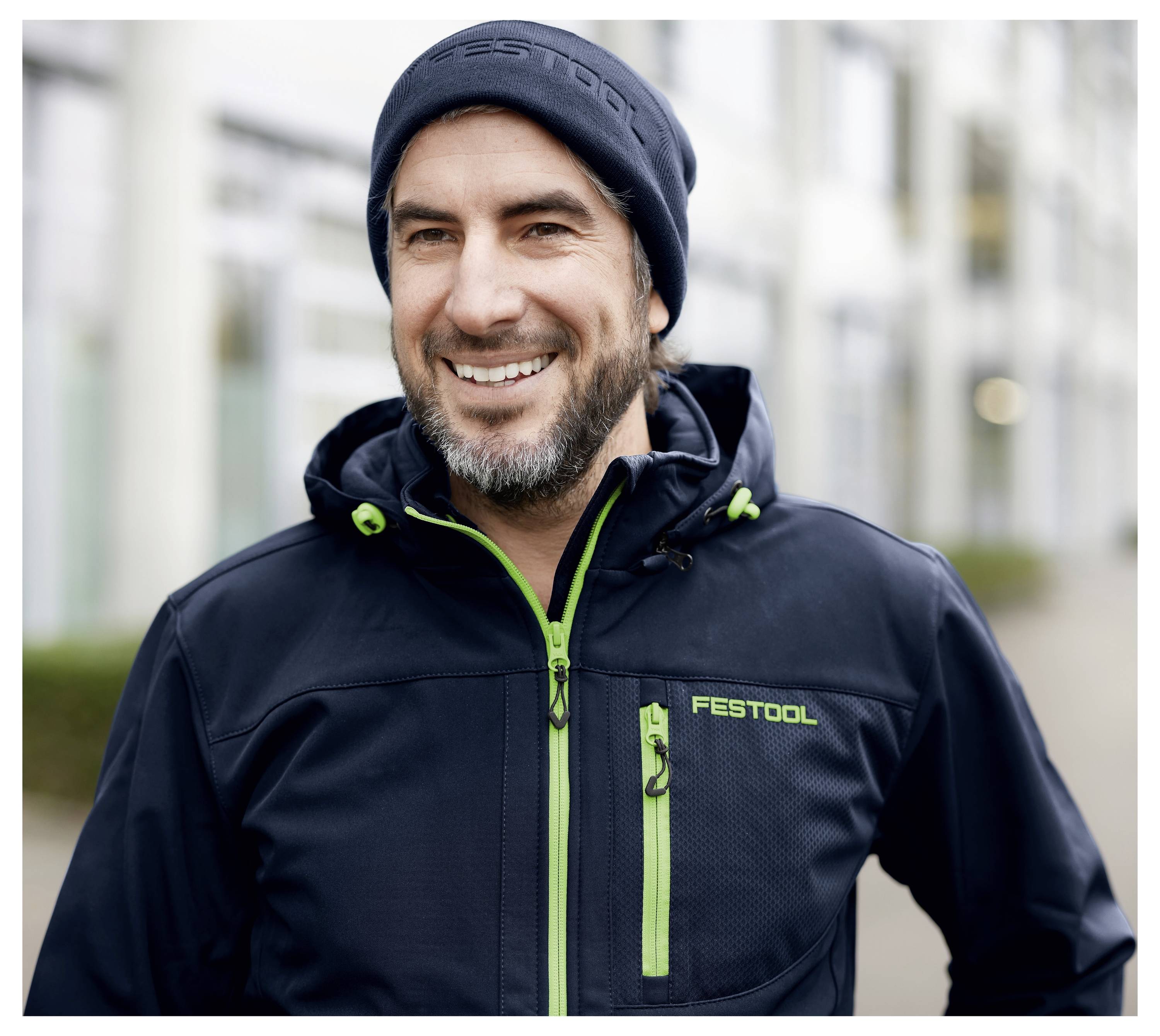 Eine Person, die eine schwarze Jacke und eine Beanie-Mütze mit „Festool