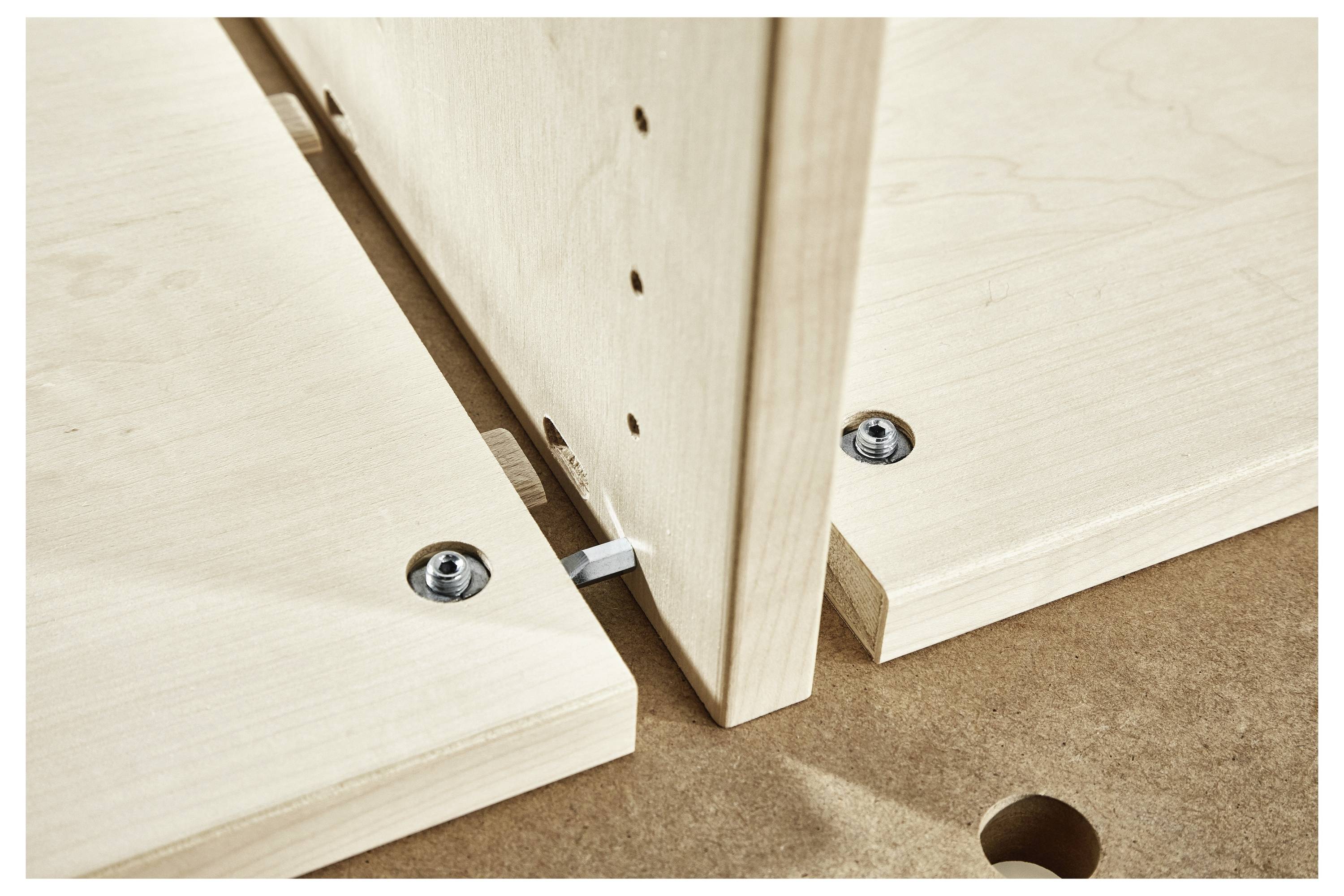 Eine Person montiert eine Schleifteller-Maschine mit einem kreisförmigen Schleifpad. Das Gerät ist grau mit grünen Tasten und wird zum Schleifen von Oberflächen verwendet.