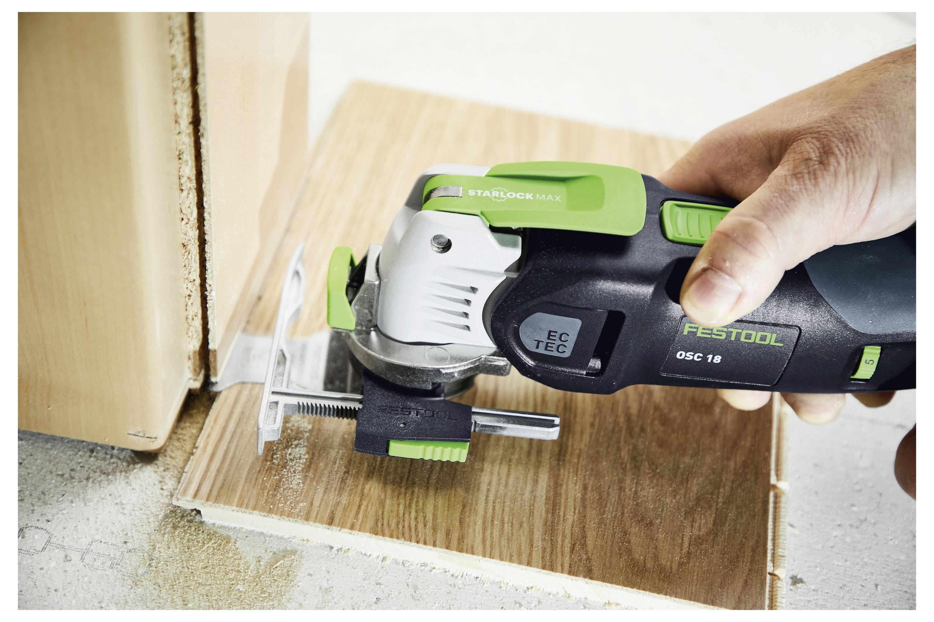 Eine Person nutzt eine Festool Akku-Säge, um ein Holzpaneel zu schneiden. Die Säge ist an der Kante des Panels positioniert und zeigt Präzision und Detailgenauigkeit.