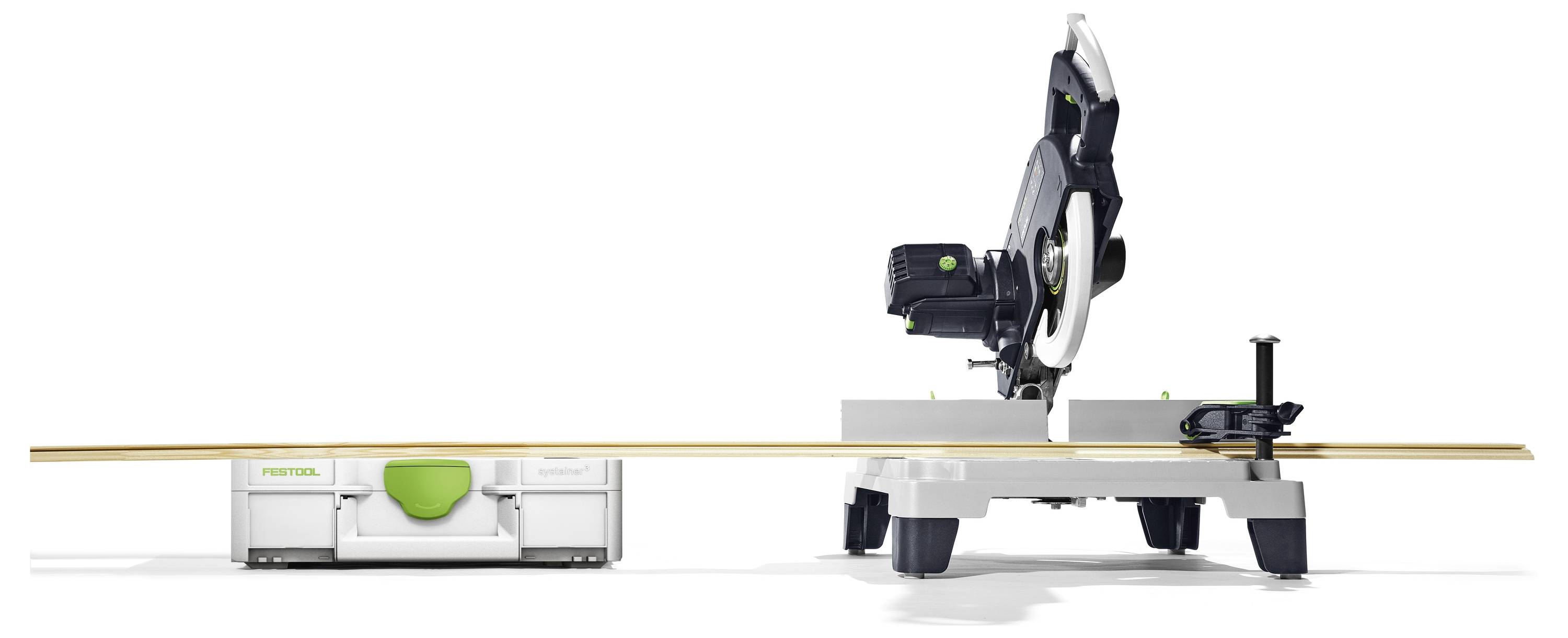Eine Gehrungssäge auf einem Ständer, nach links geneigt, mit einem langen Holzstück. Ein Festool-Koffer befindet sich in der Nähe und weist ebenfalls auf die Marke hin.