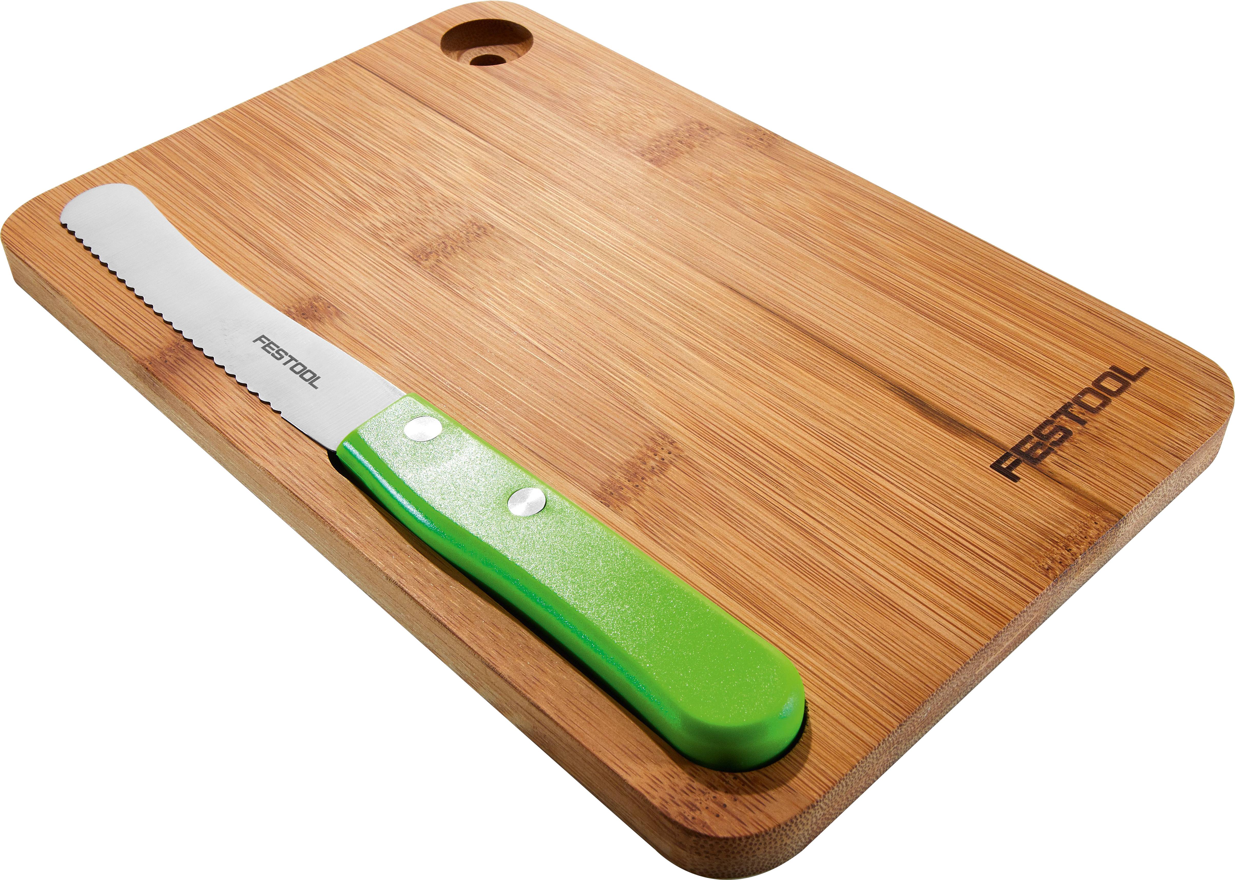 Ein Bambusschneidebrett mit einem Sägemesser mit grünem Griff oben drauf.