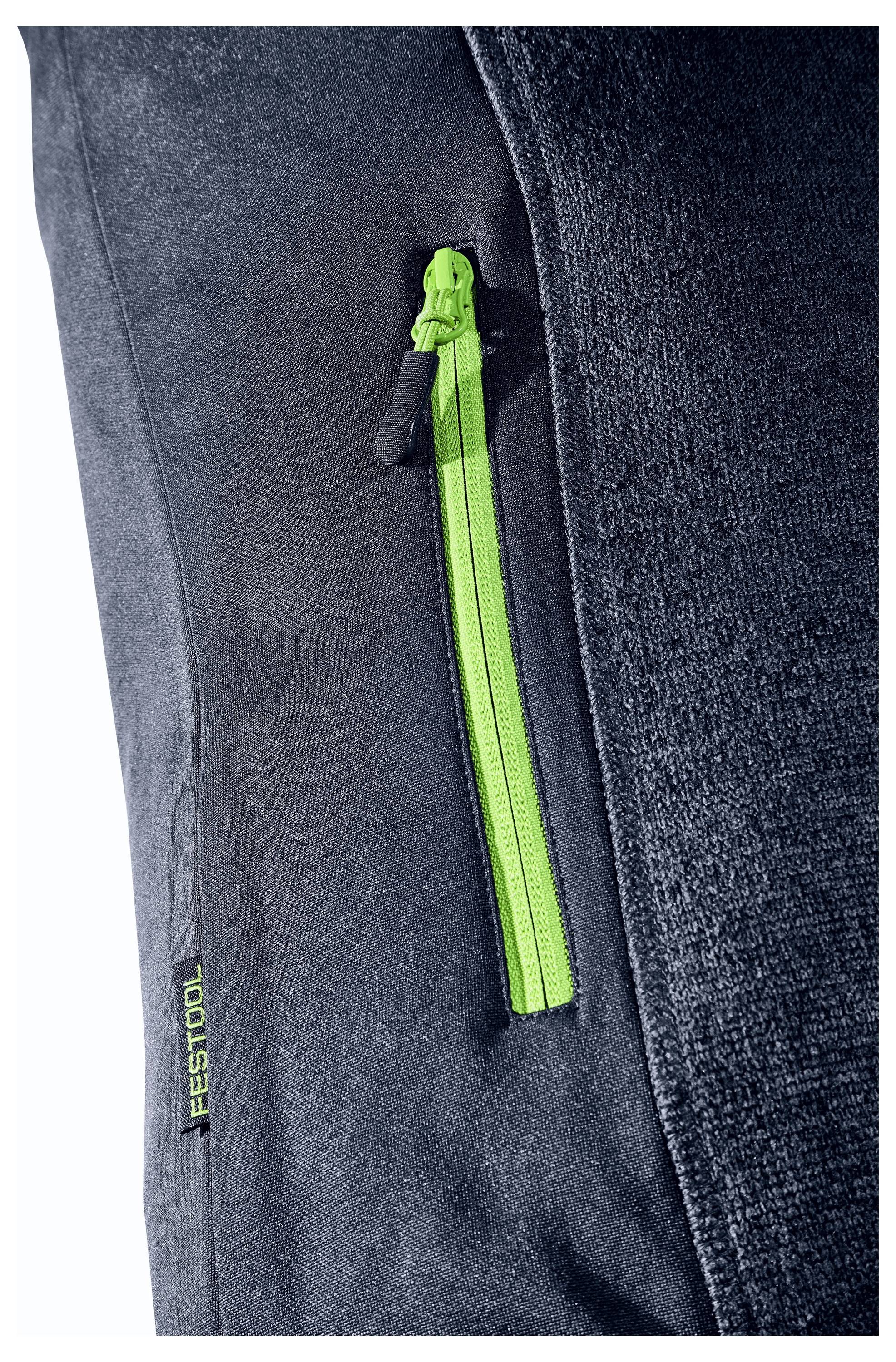 Nahaufnahme einer schwarzen Stofftasche mit einem leuchtend grünen Reißverschluss und einem 